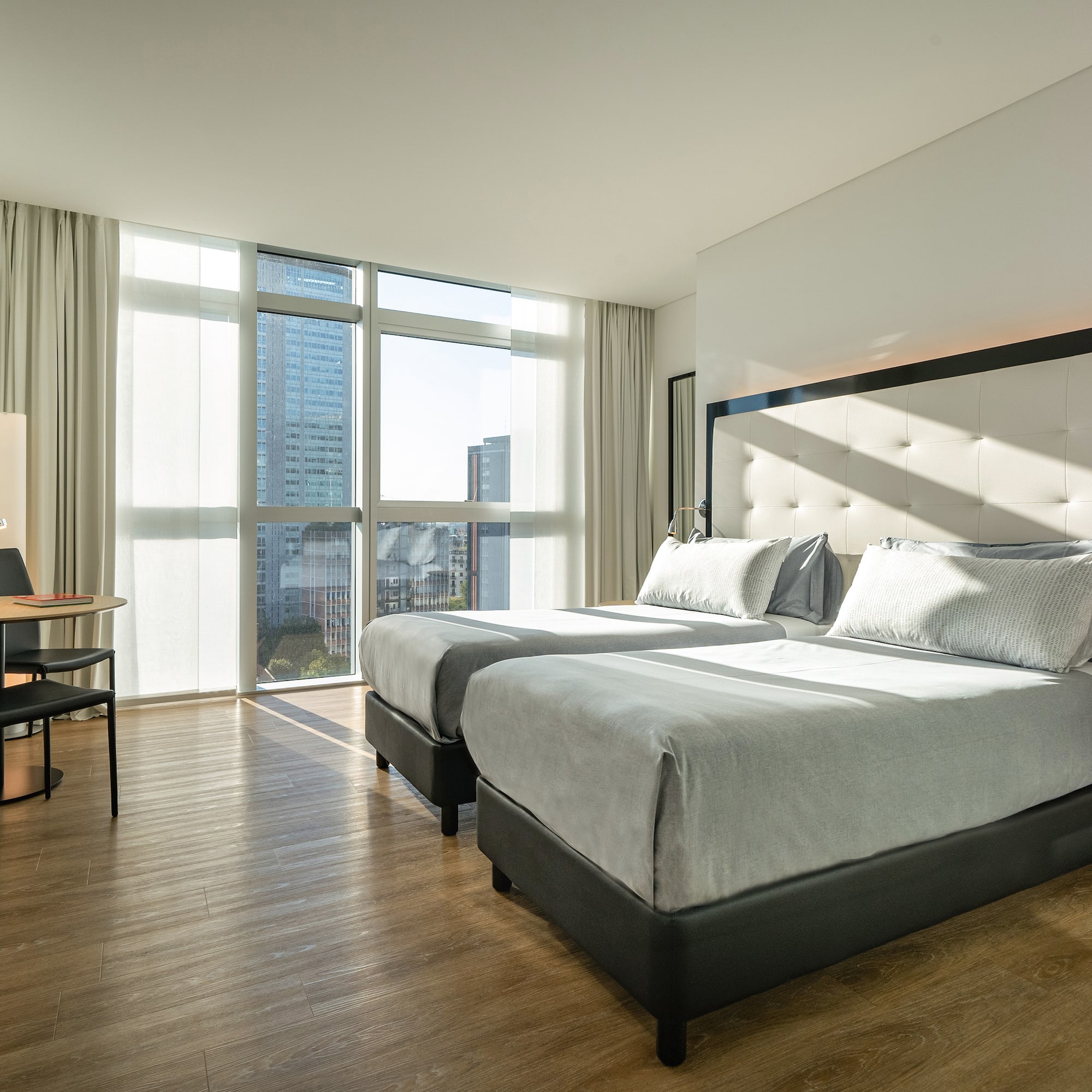 a room with two beds and a desk