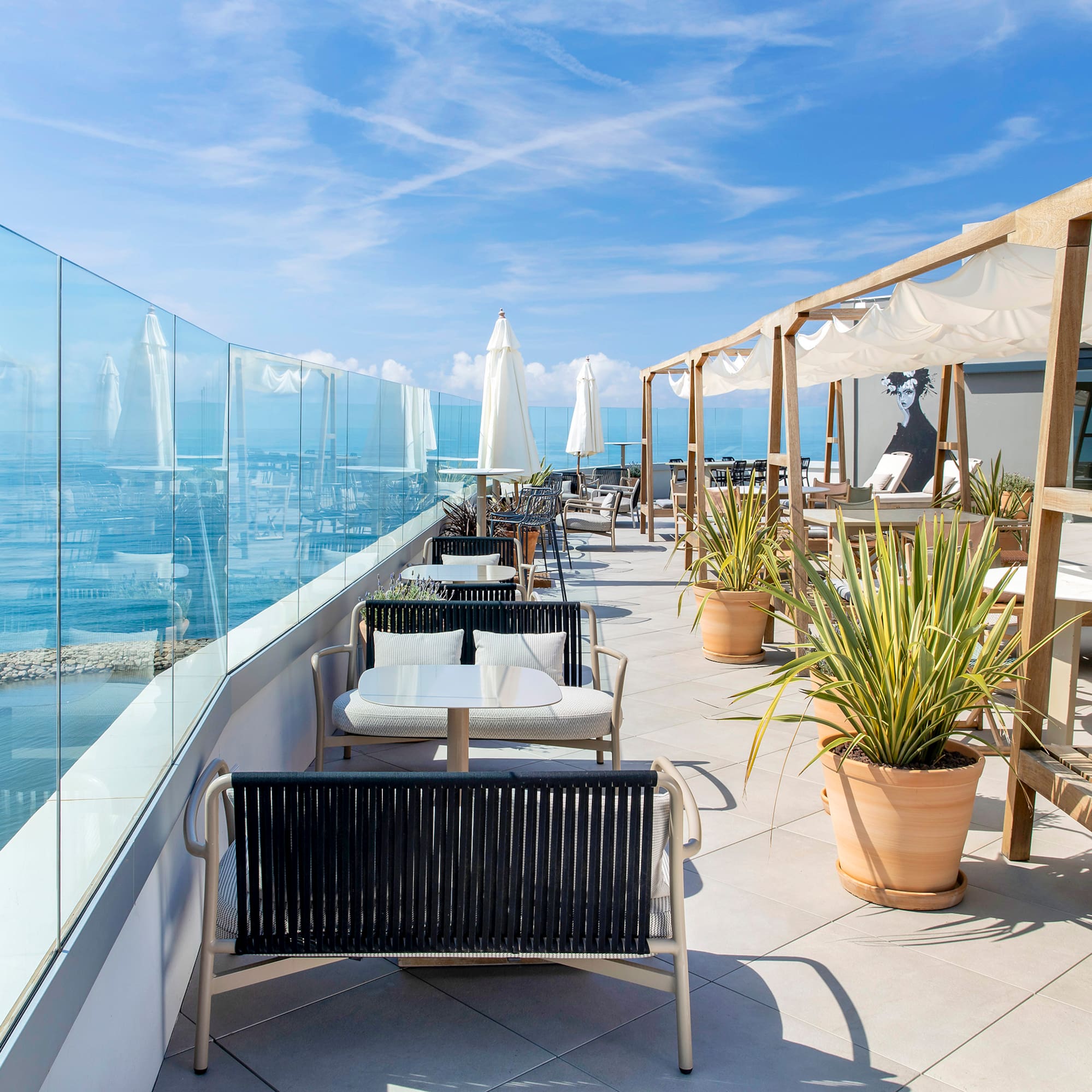 a patio with chairs and tables and umbrellas on a sunny day
