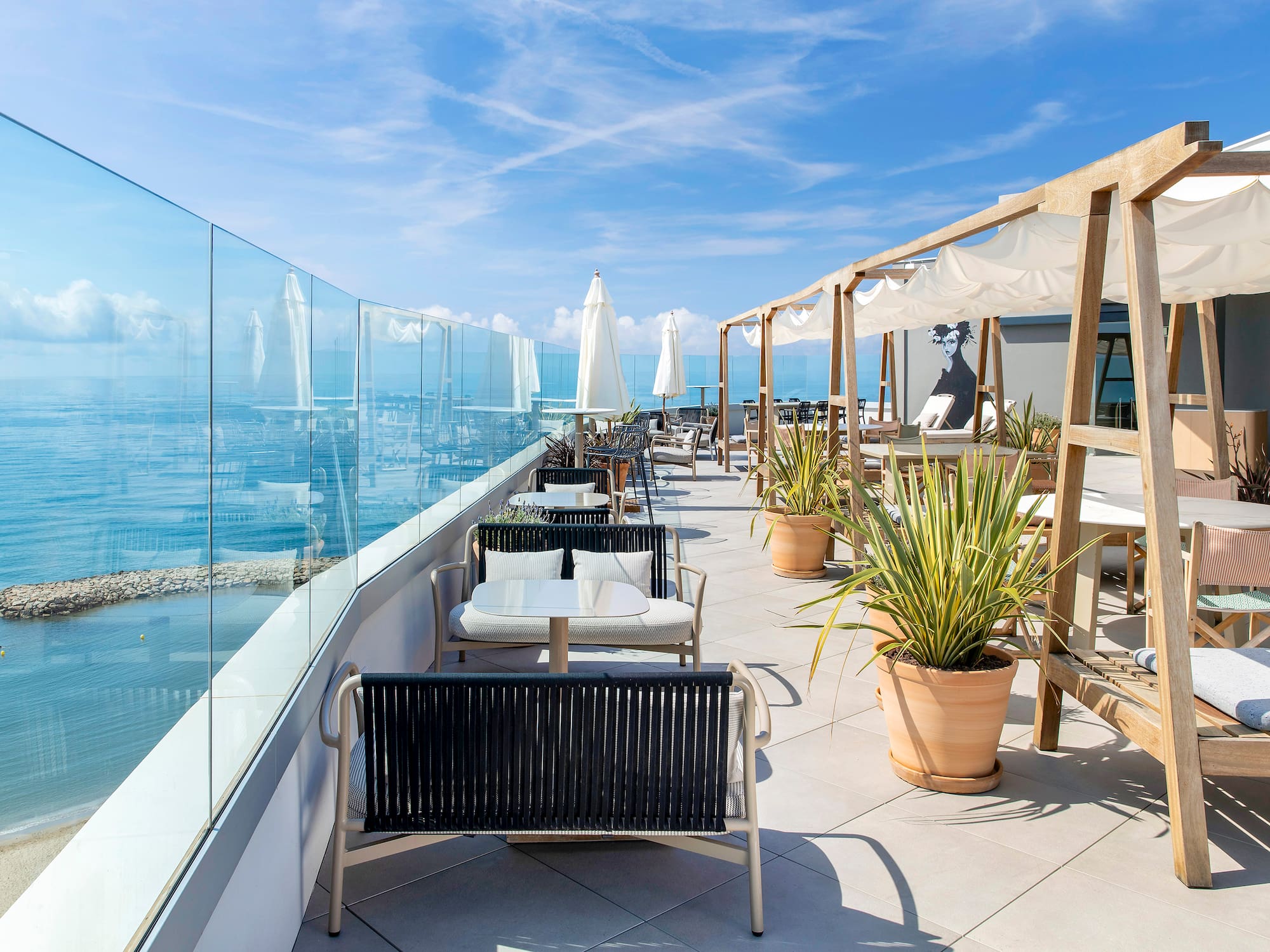a patio with chairs and tables and umbrellas on a sunny day