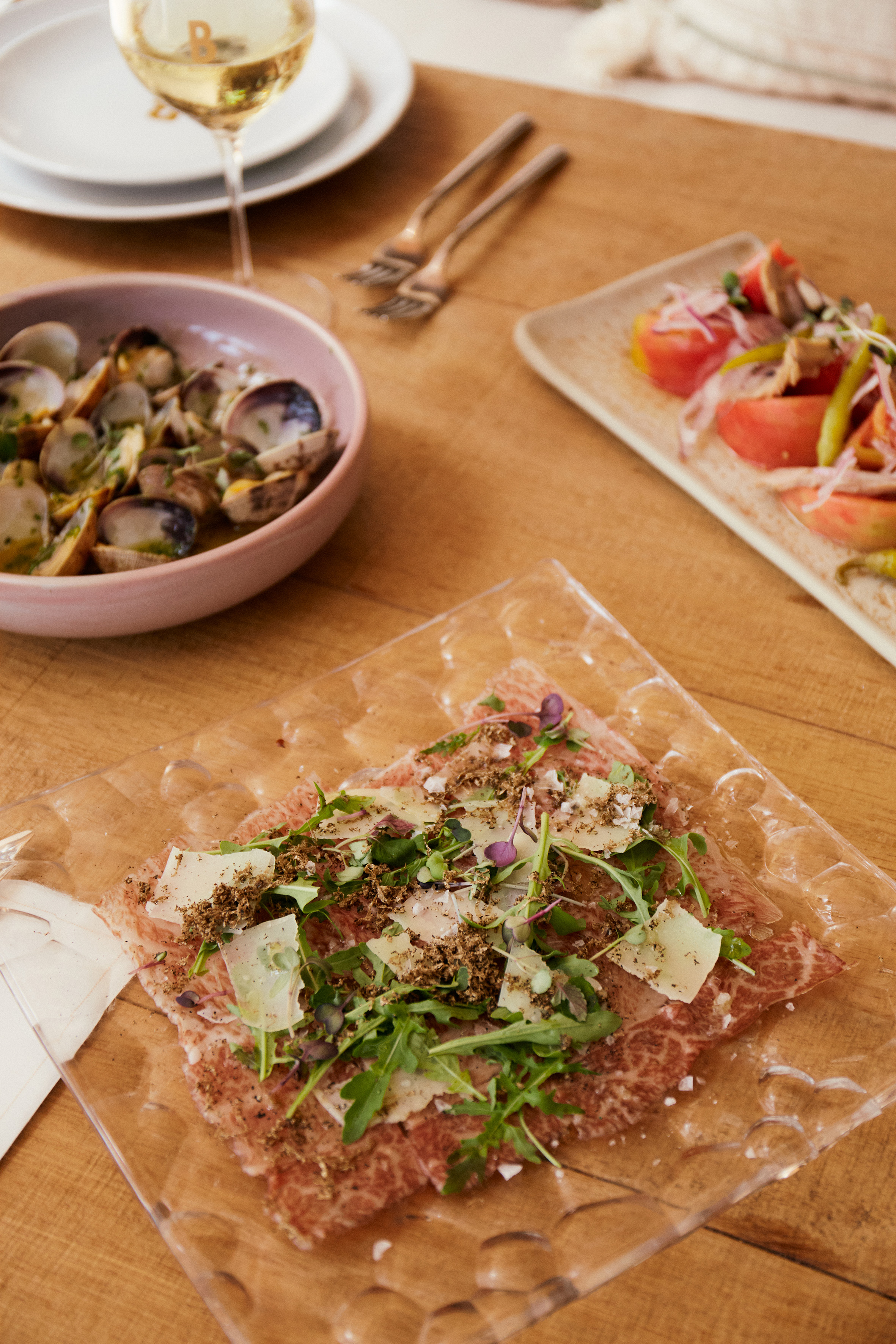 Beef carpaccio with truffle, Parmesan, arugula. Clams and tomato salad.