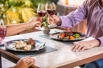 a group of people clinking glasses of wine at a table