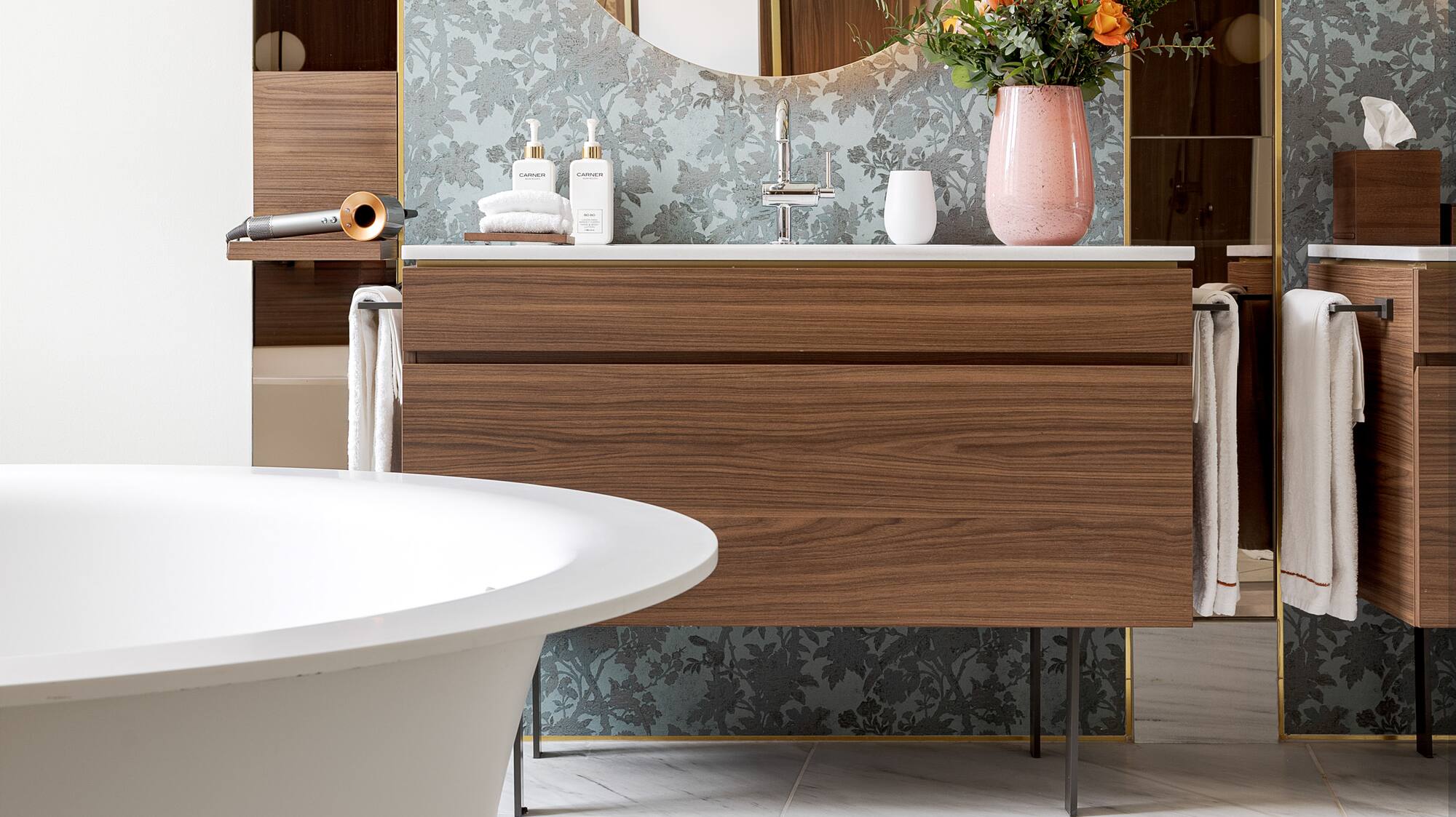 a bathroom with a round mirror and a tub