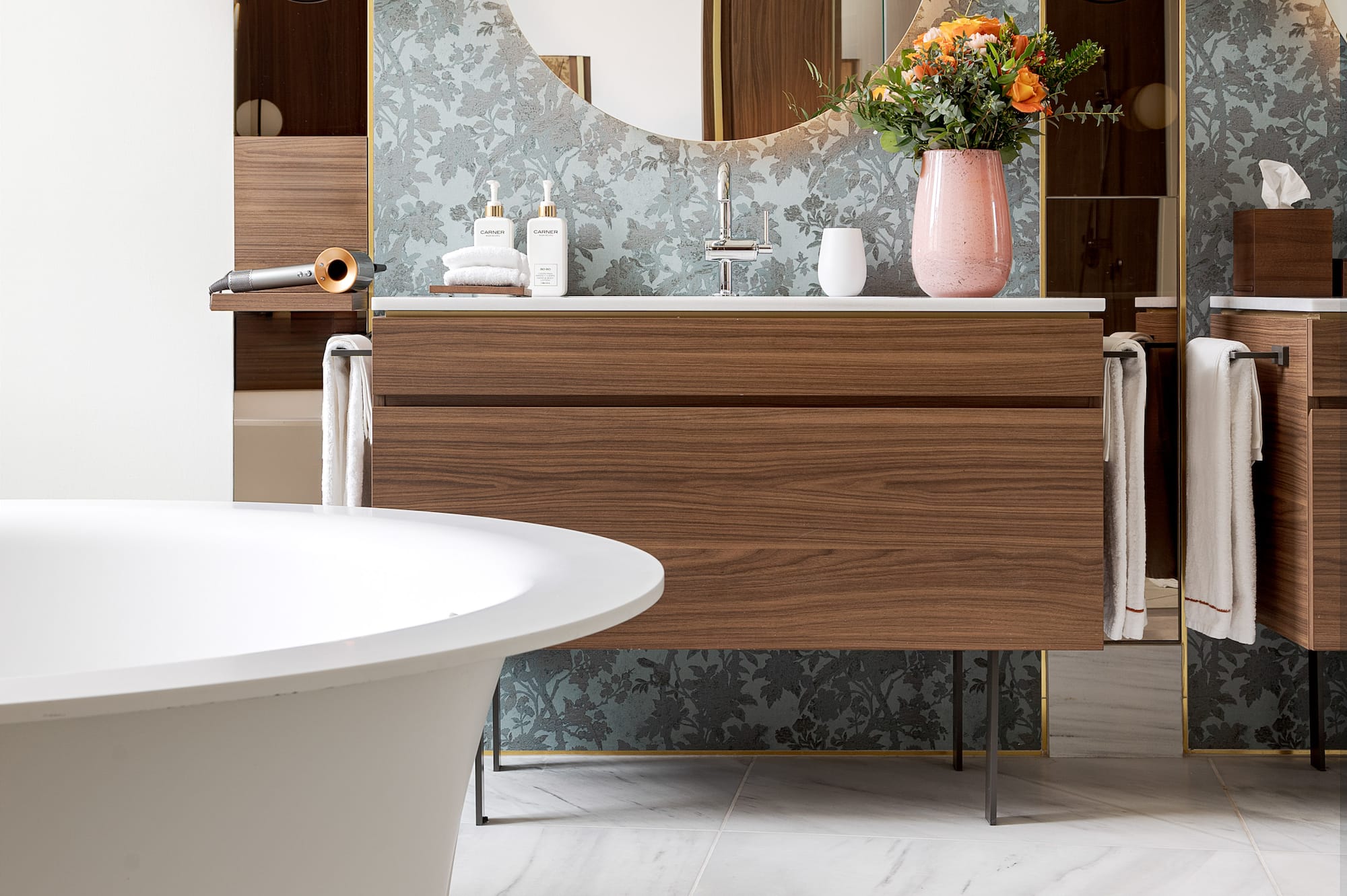 a bathroom with a round mirror and a tub
