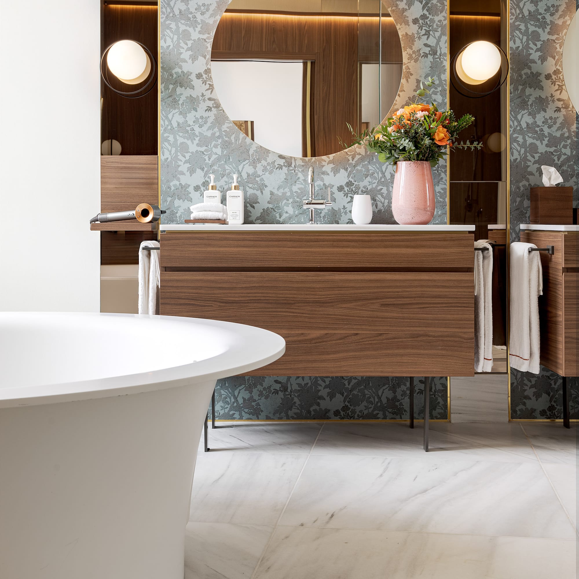 a bathroom with a round mirror and a tub