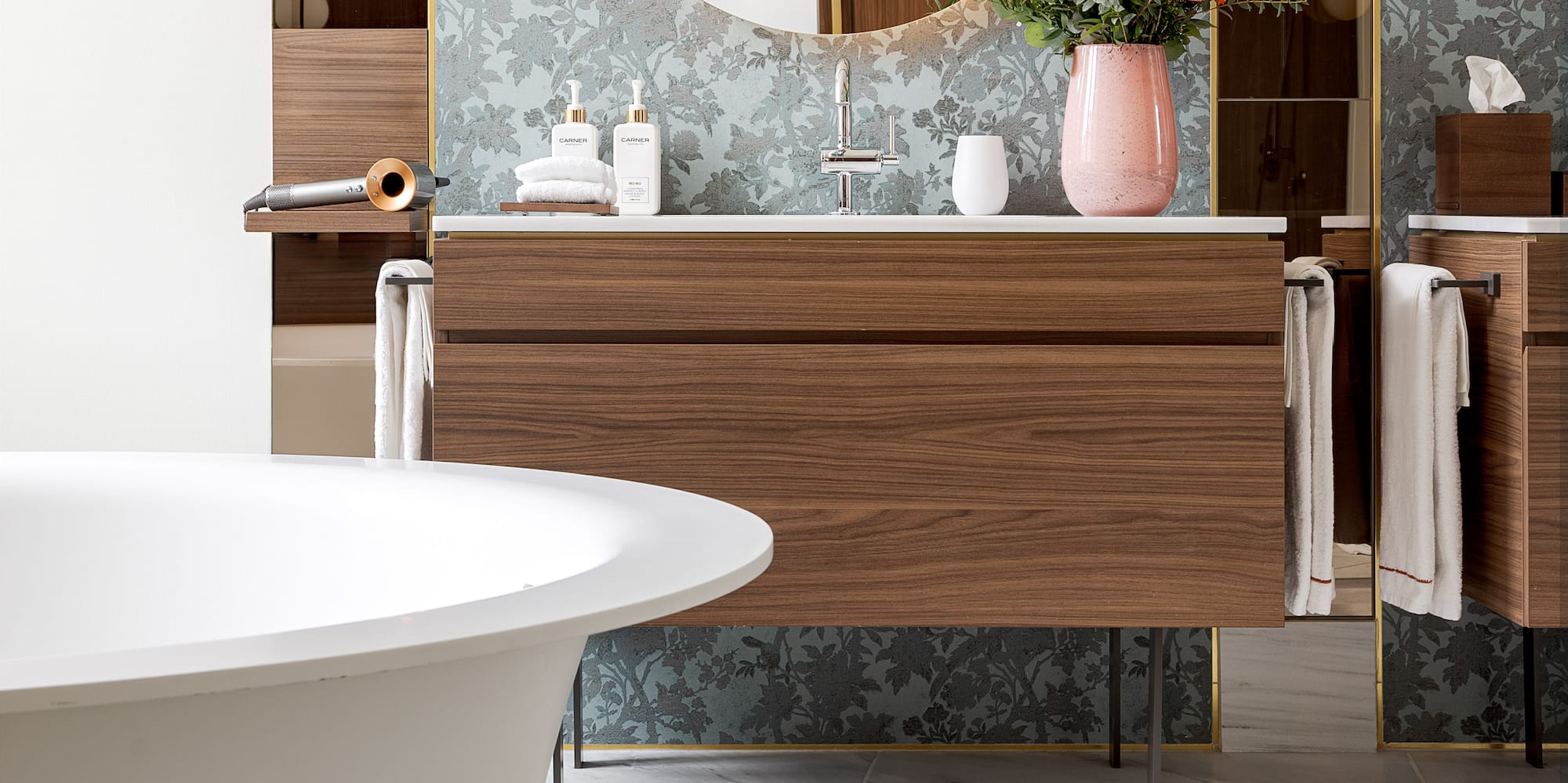 a bathroom with a round mirror and a tub