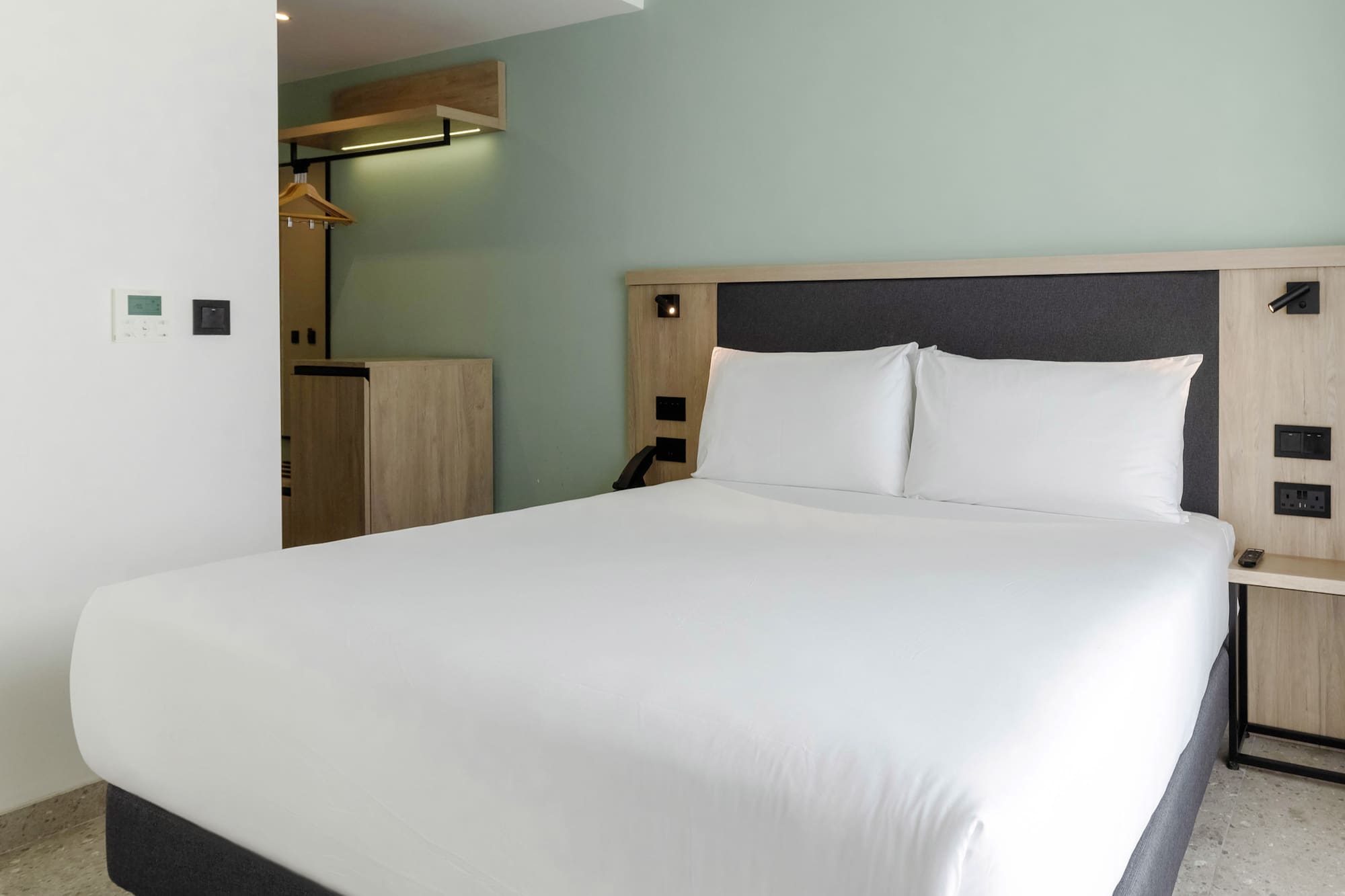 a bed with white sheets and a wooden headboard