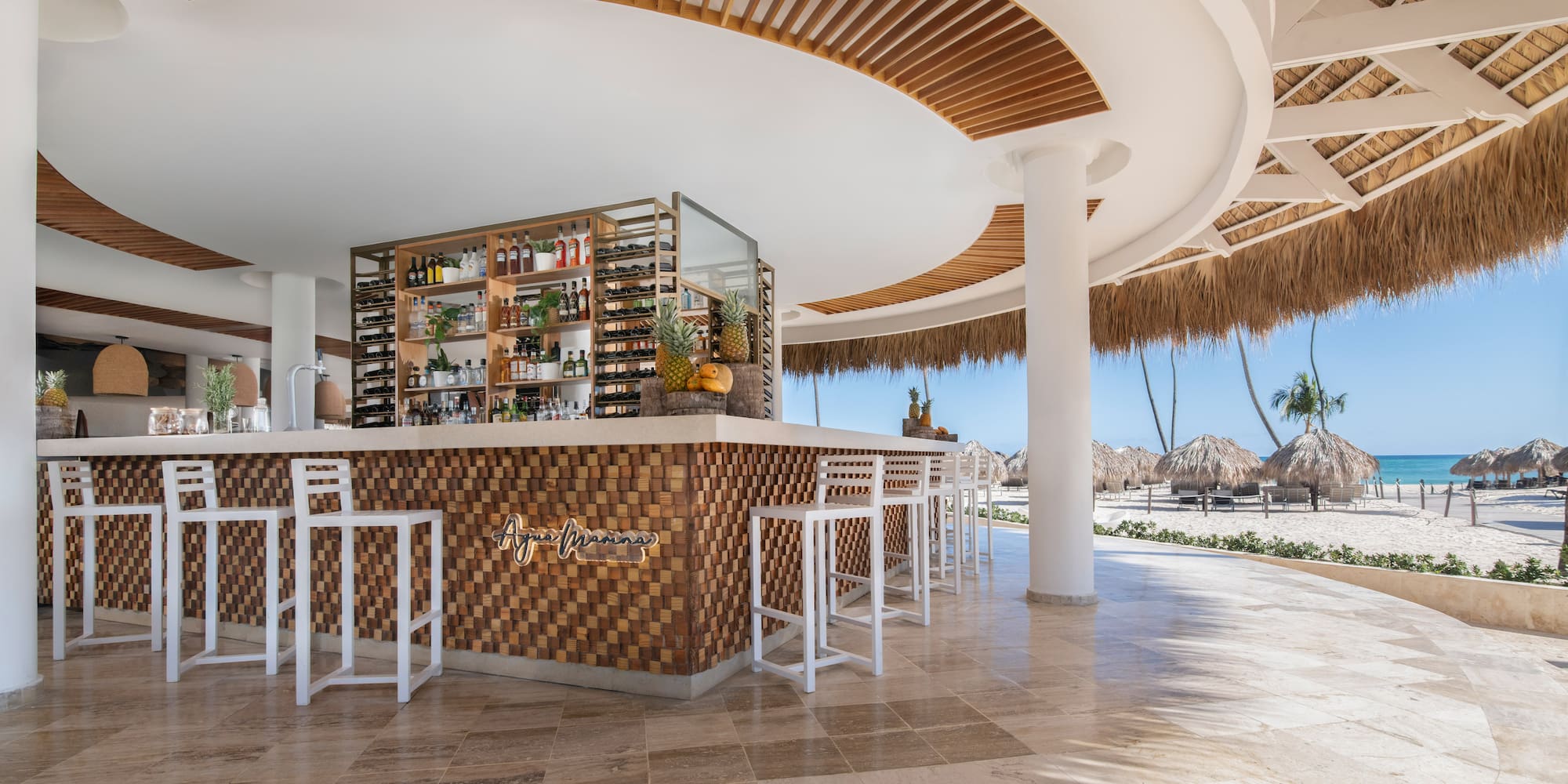 a bar with a shelf and chairs in a beach bar
