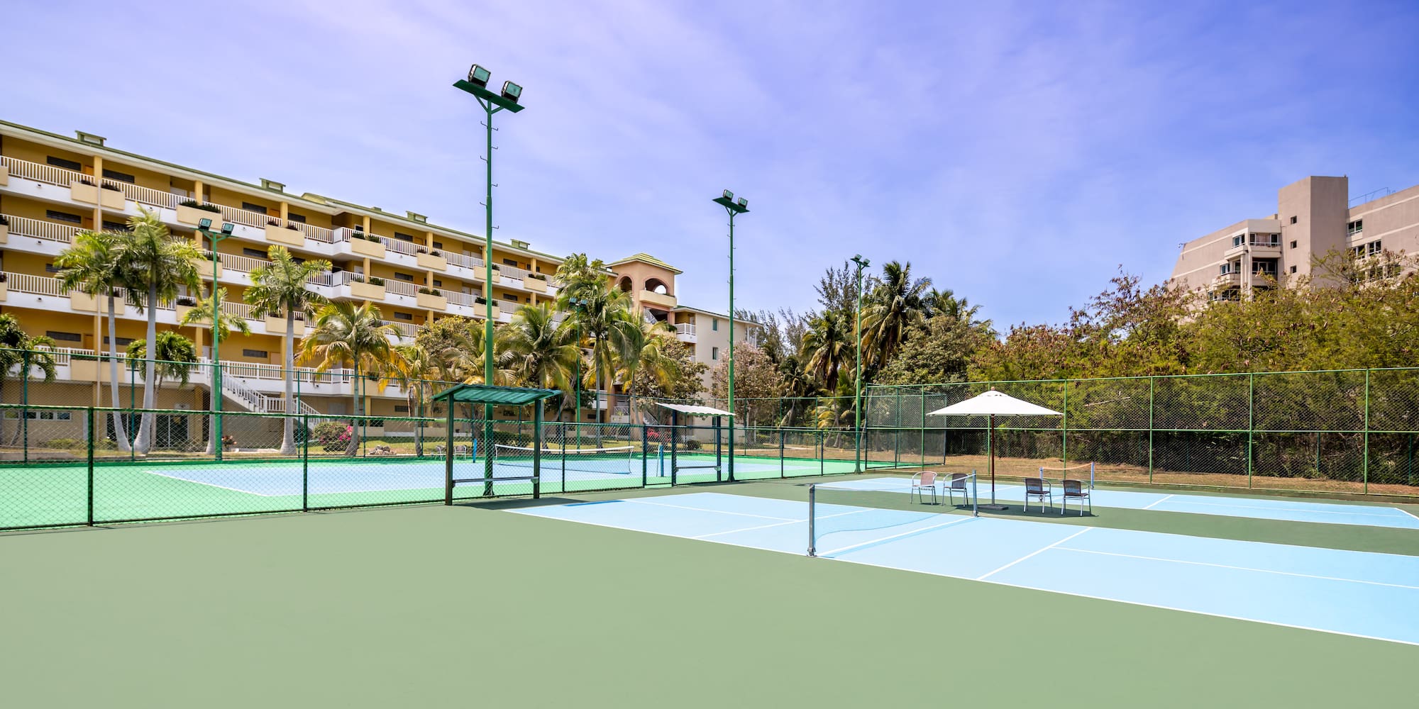 a tennis court with a building in the background