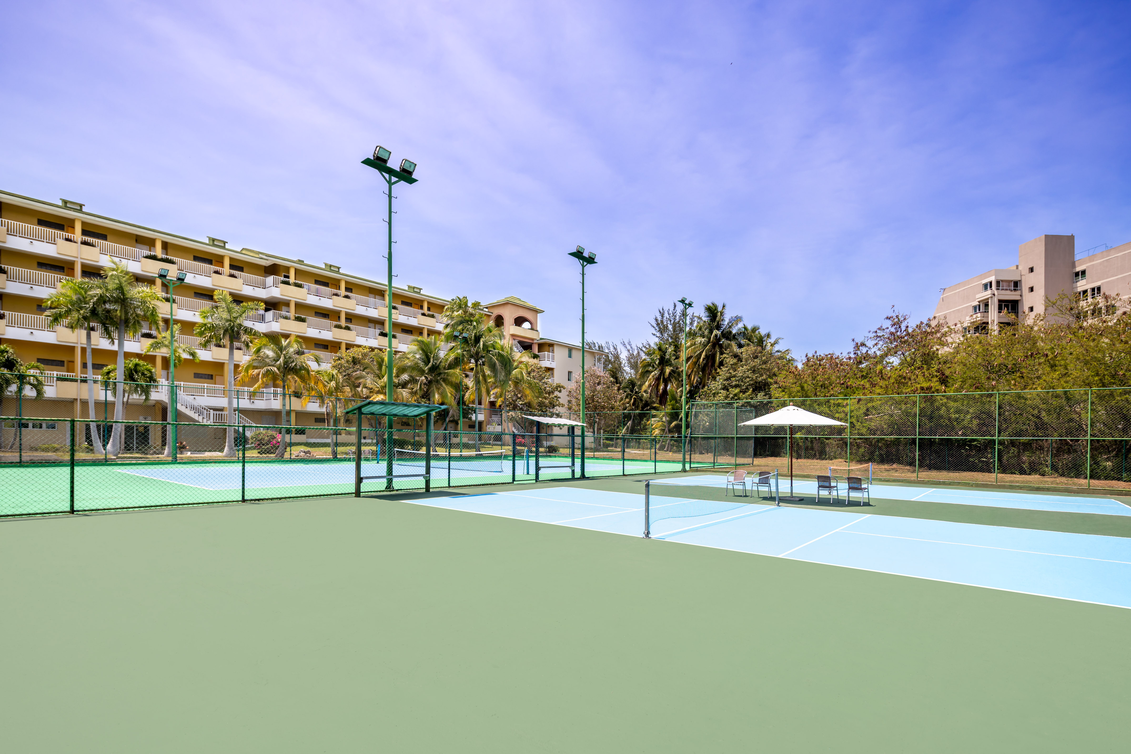 a tennis court with a building in the background