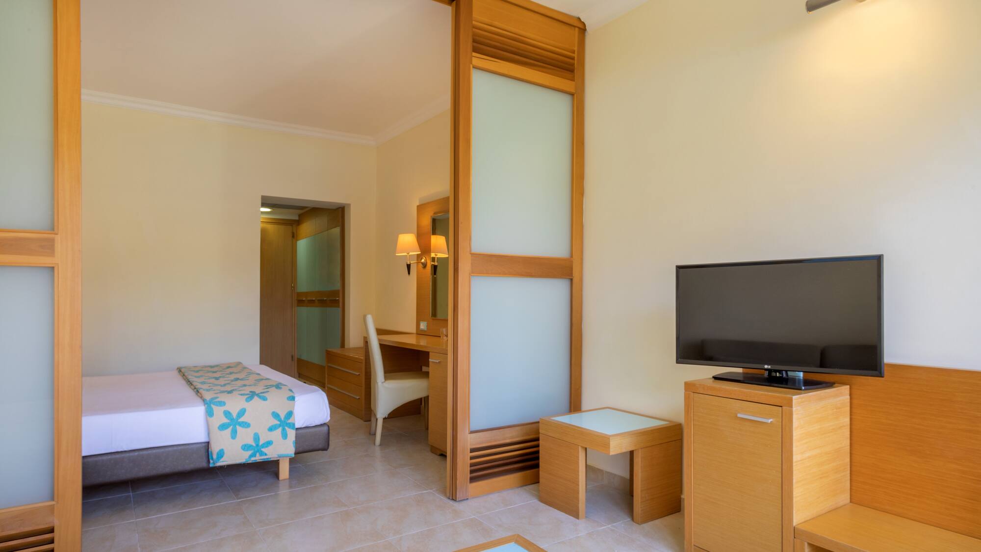 a room with a bed and a television