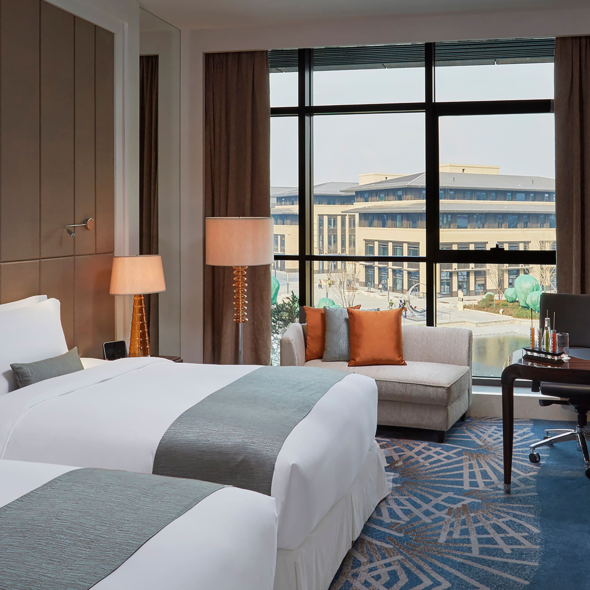 a hotel room with two beds and a chair