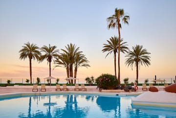 a pool with palm trees and a pool in the background