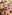 Wooden tiered stand with assorted mini tarts, wild strawberry tart in focus.