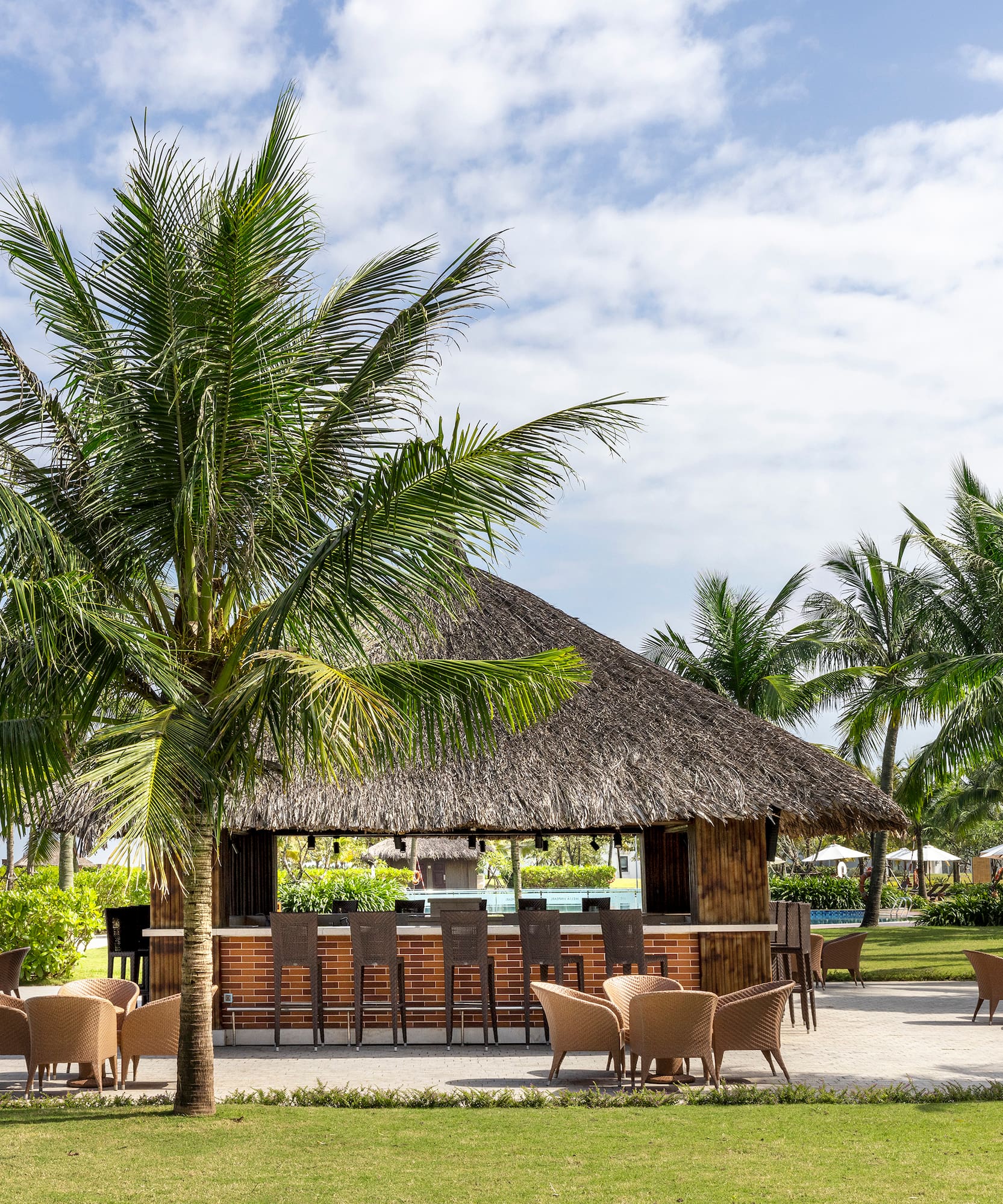 a bar with chairs and a thatched roof