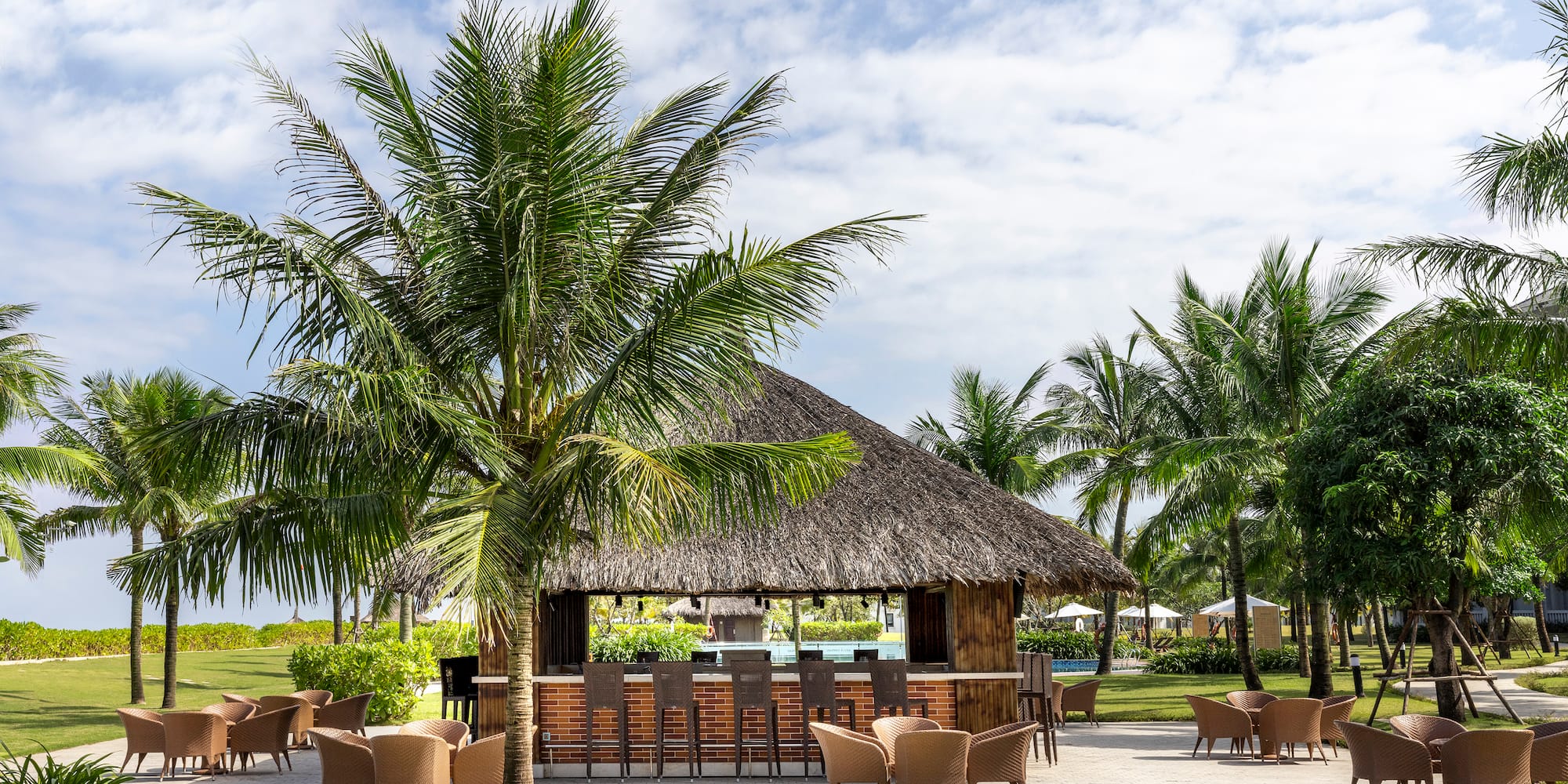 a bar with chairs and a thatched roof