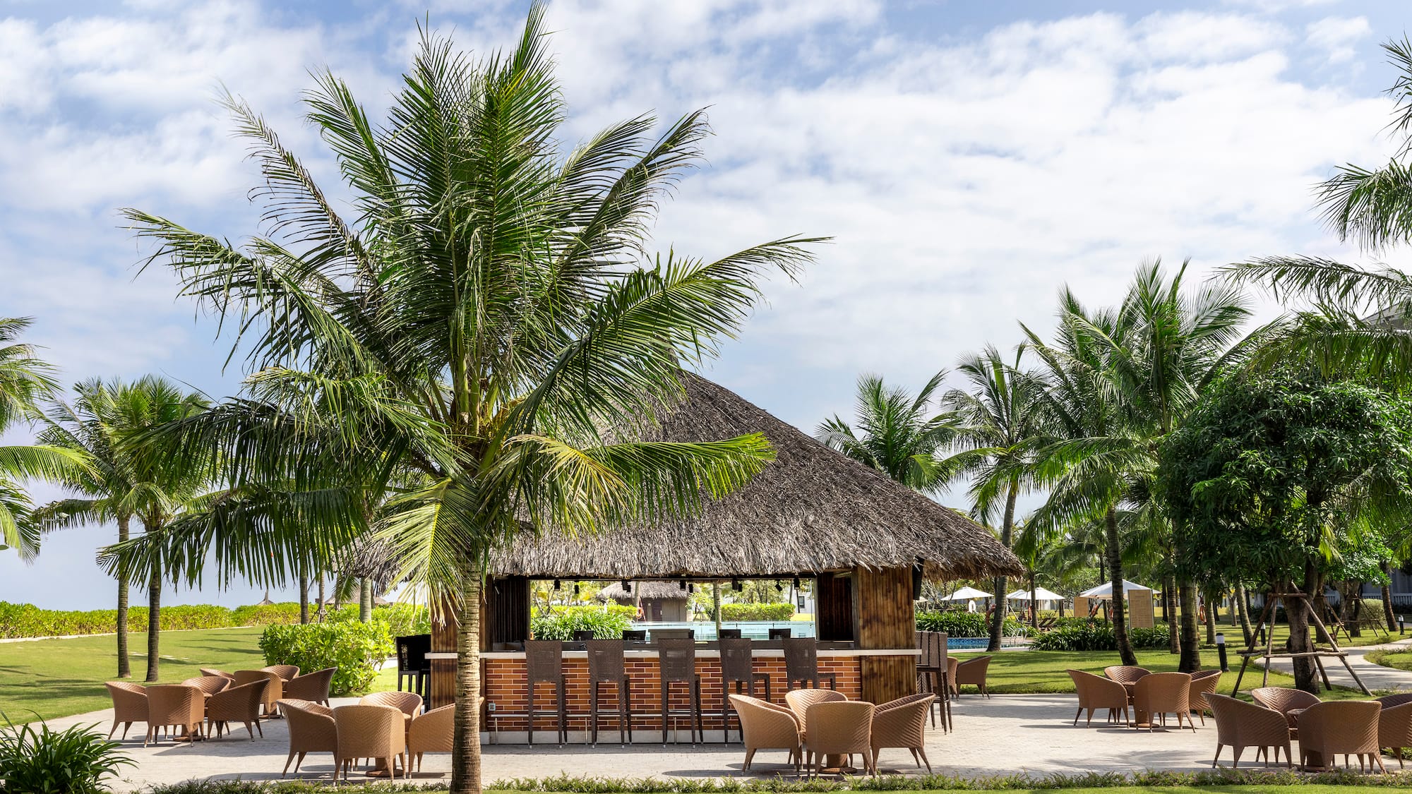 a bar with chairs and a thatched roof