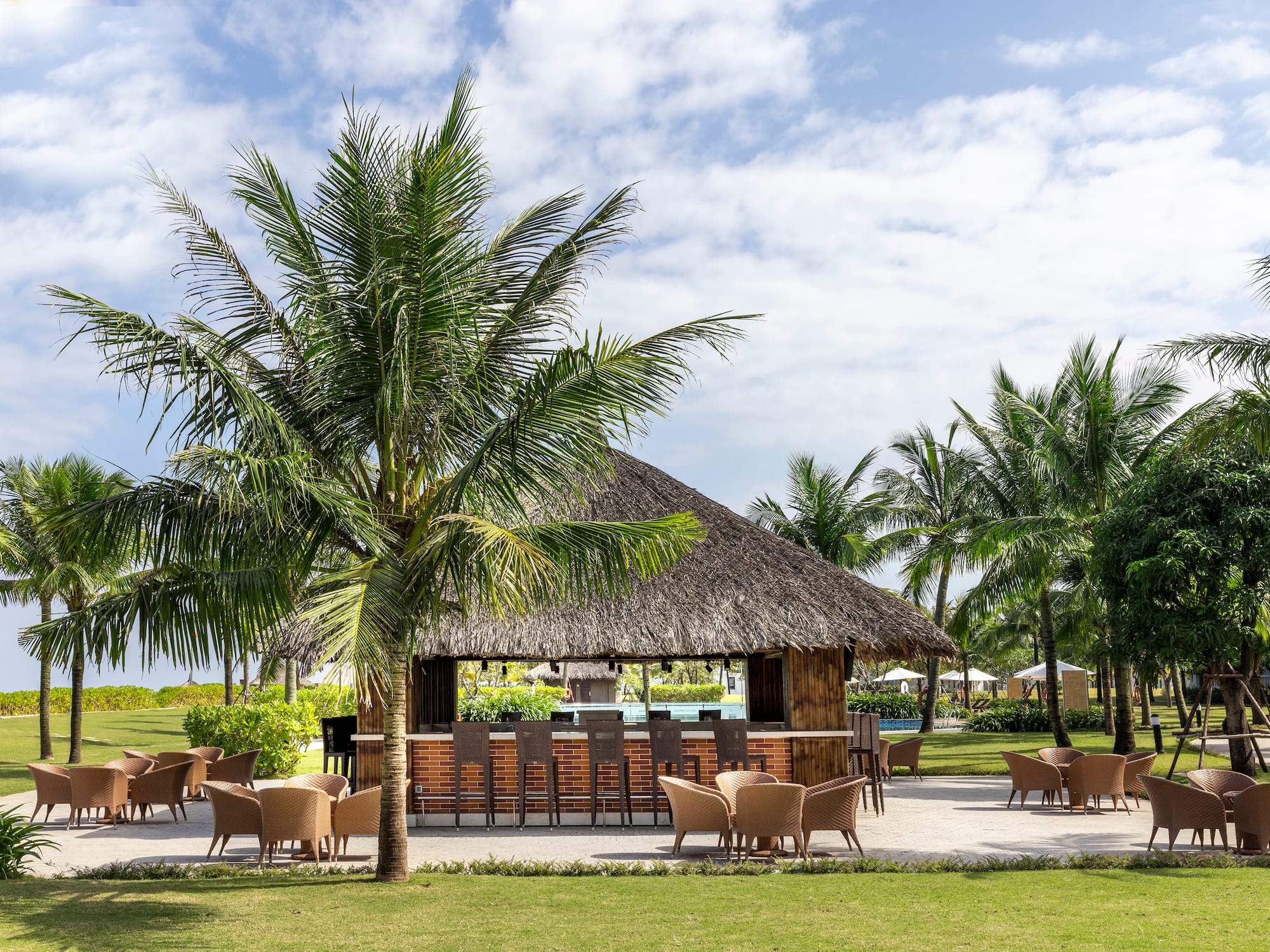 a bar with chairs and a thatched roof