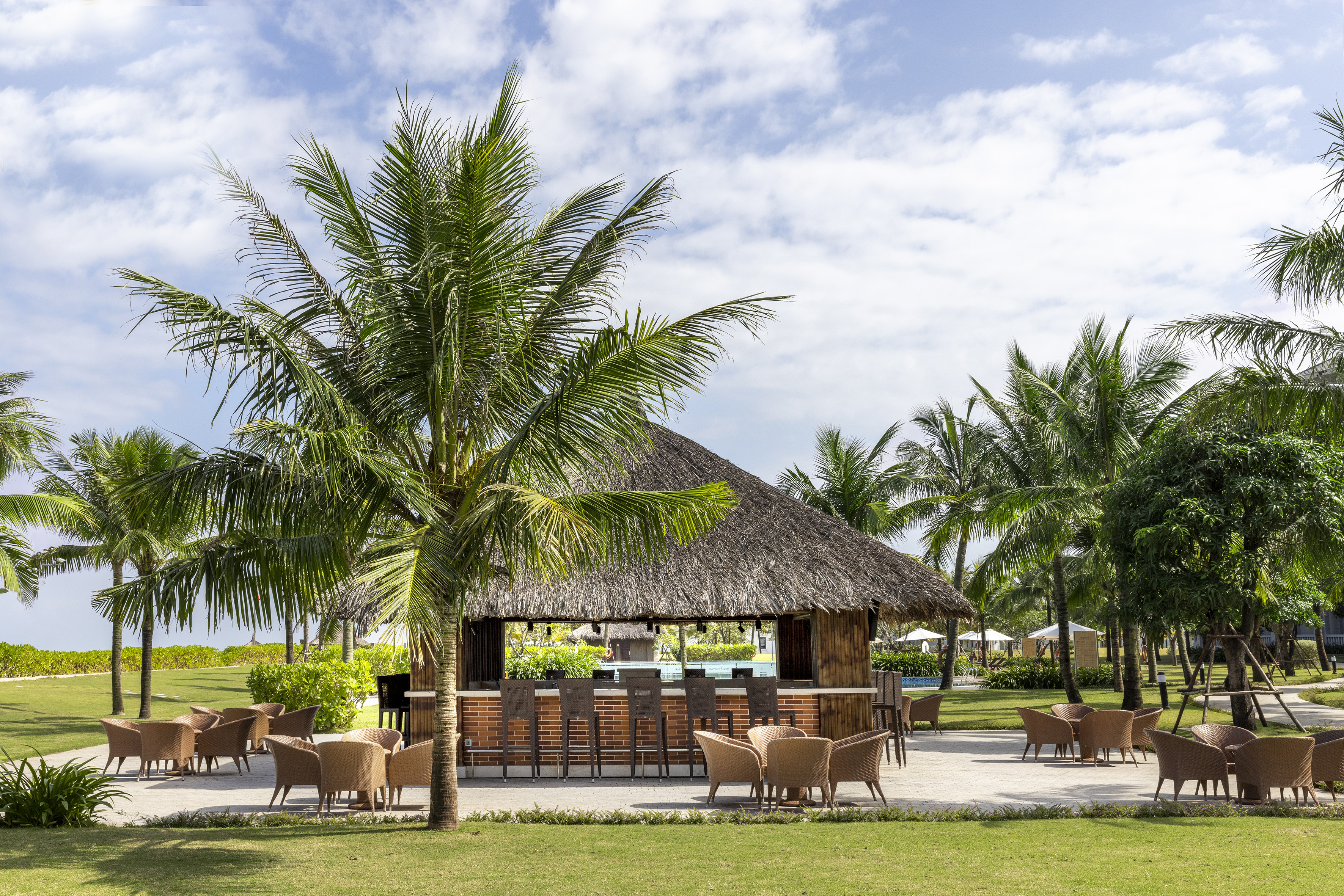 a bar with chairs and a thatched roof