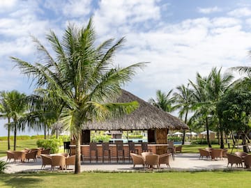 a bar with chairs and a thatched roof