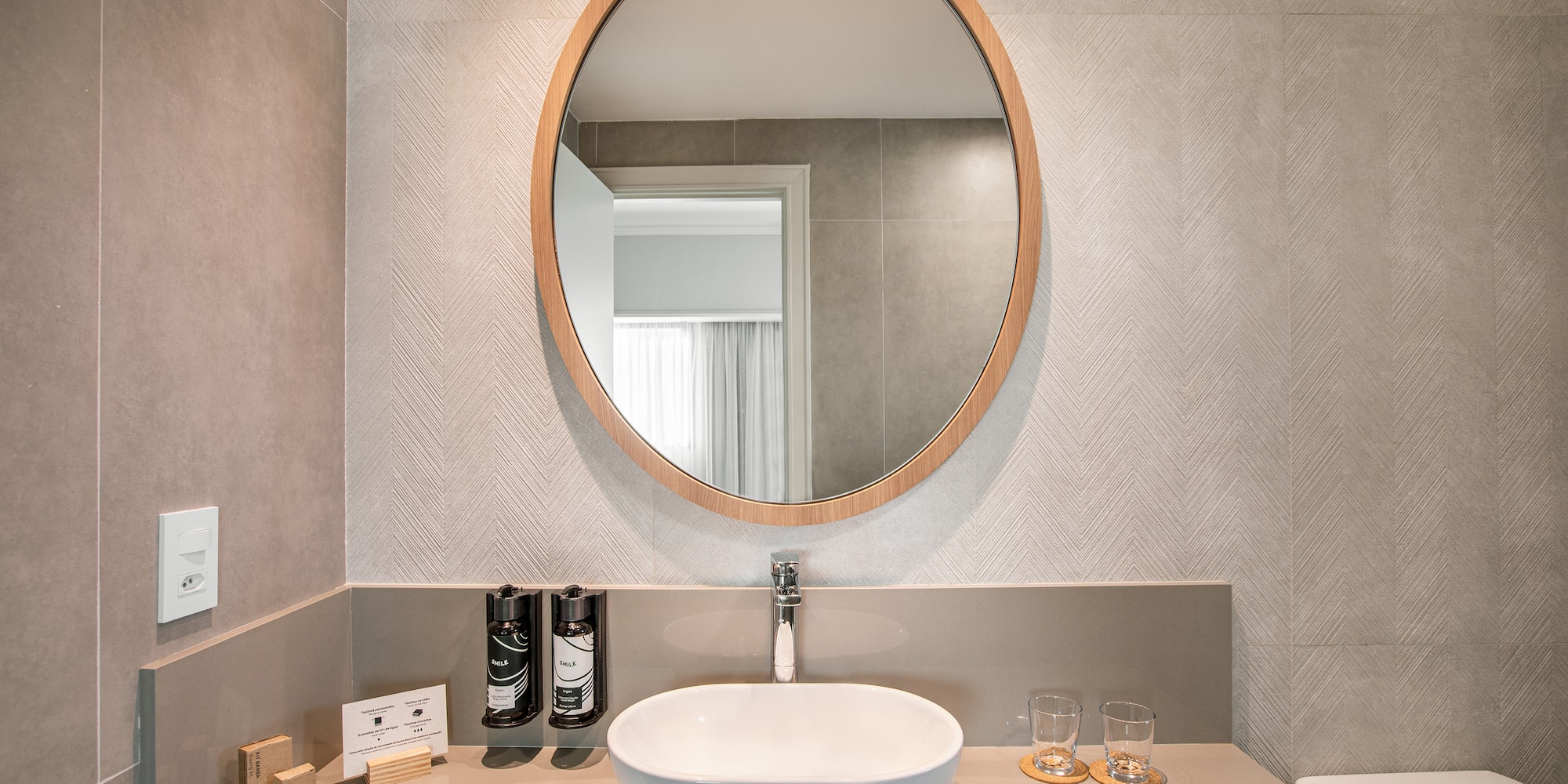 a bathroom with a round mirror