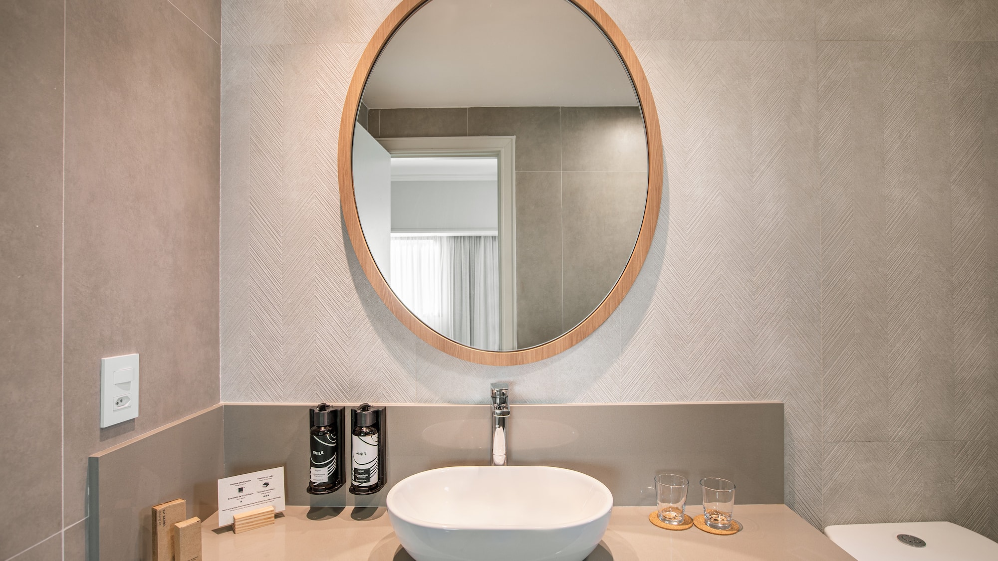 a bathroom with a round mirror
