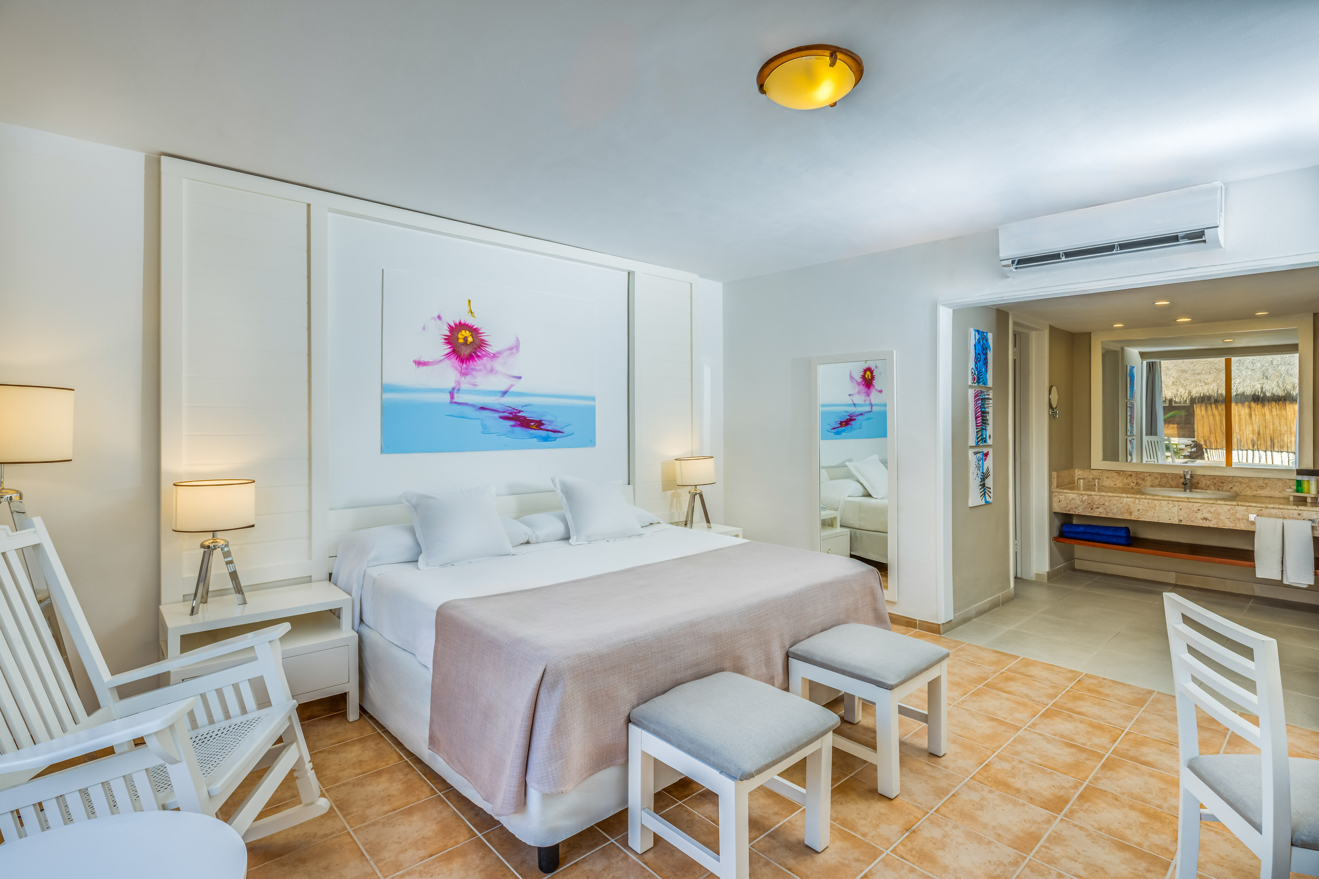 a bedroom with a bed and chairs