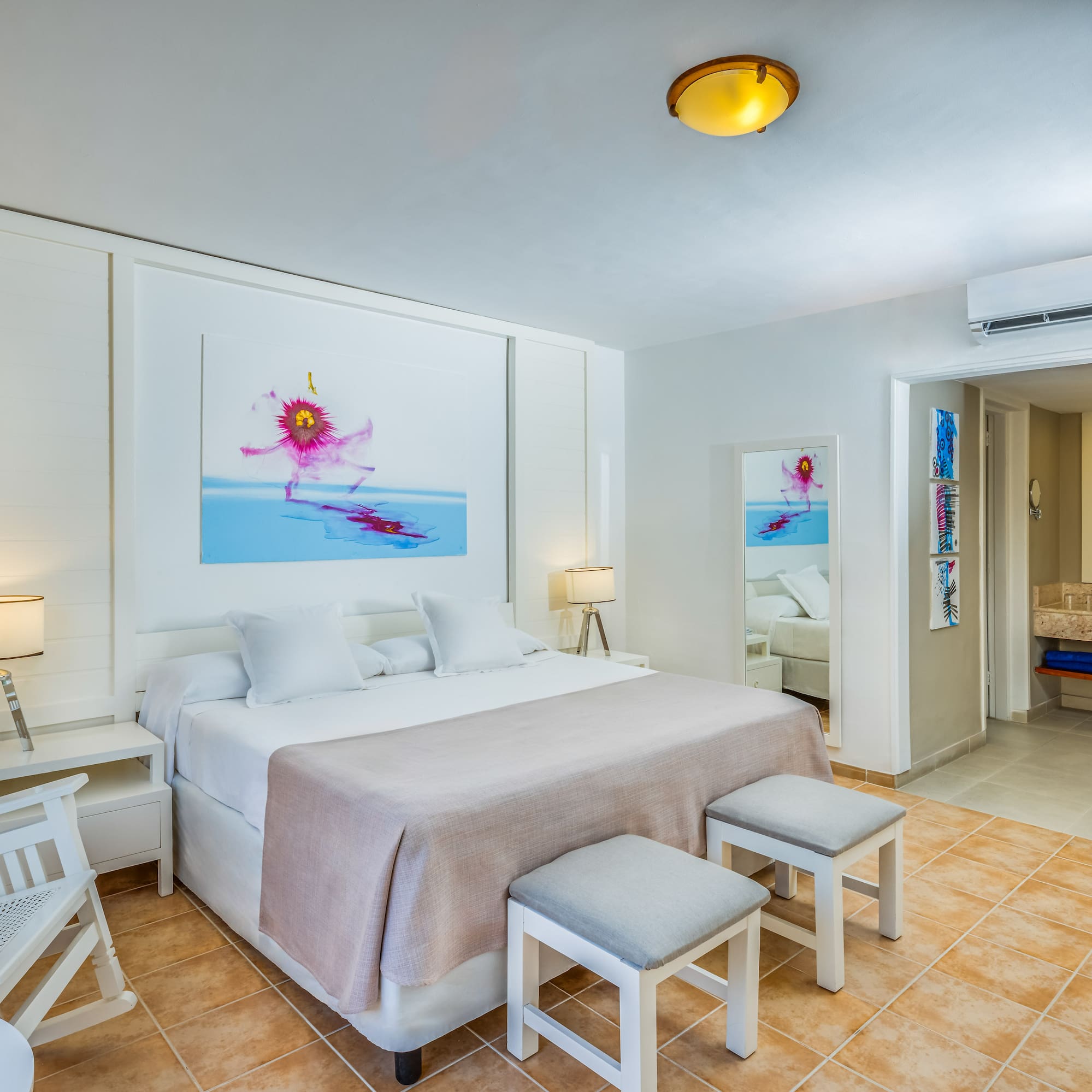 a bedroom with a bed and chairs