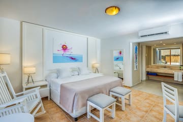 a bedroom with a bed and chairs