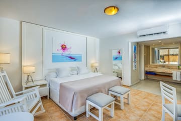 a bedroom with a bed and chairs