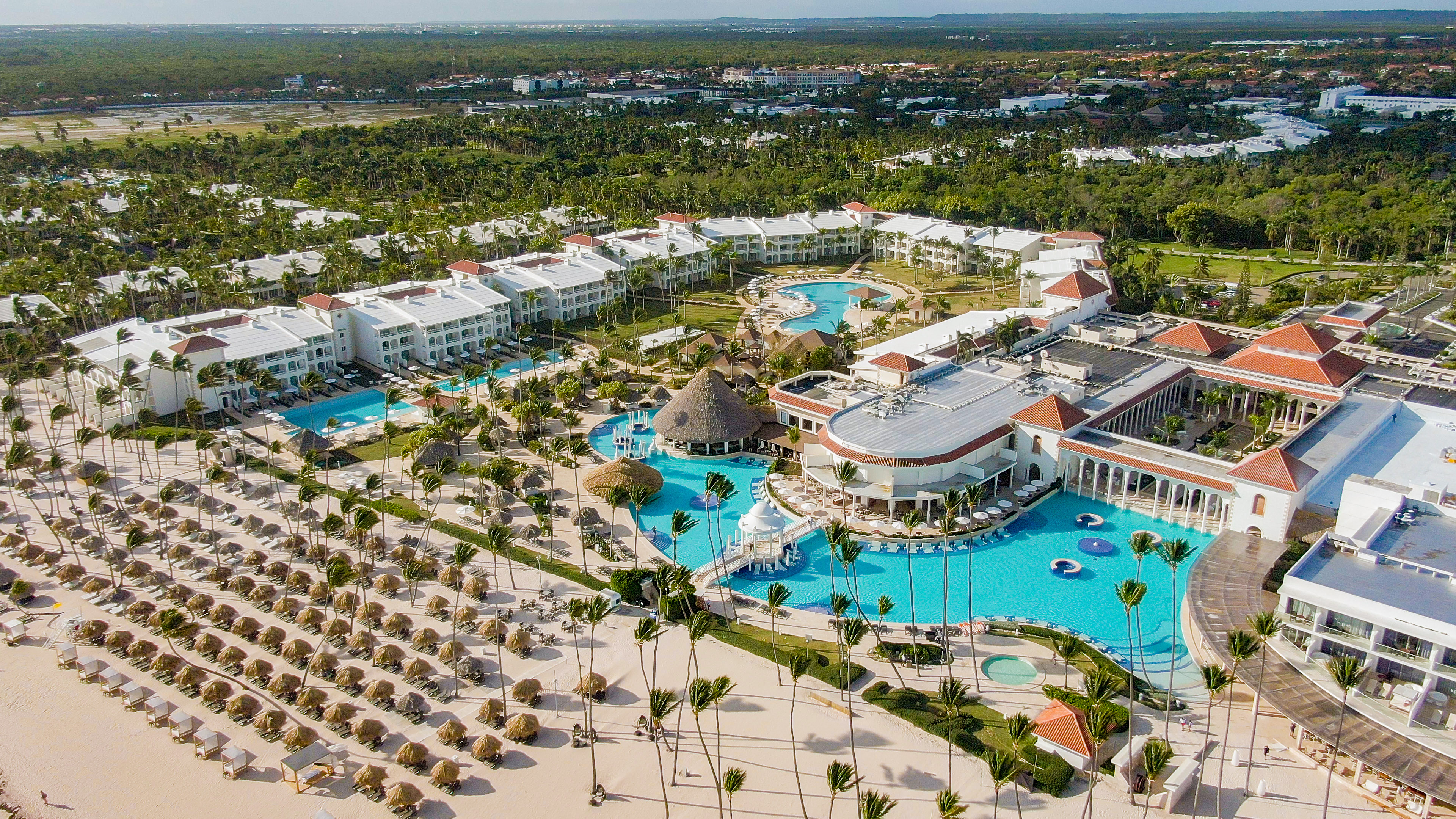 a large resort with a pool and palm trees.