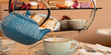 a person pouring tea into a cup