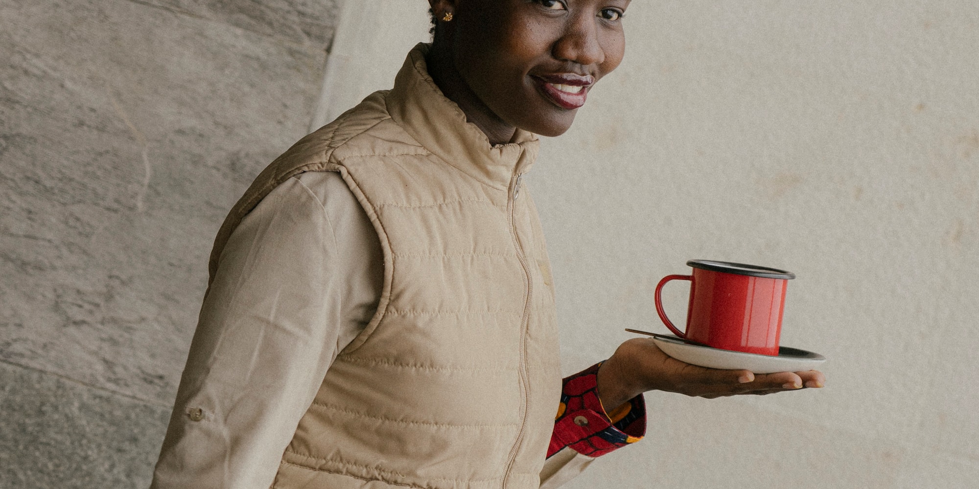 a woman holding a red cup and saucer