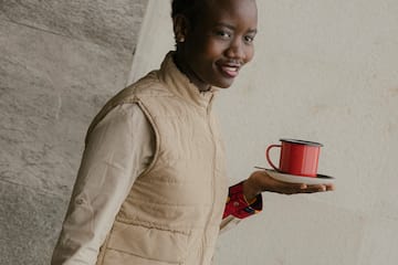 a woman holding a red cup and saucer