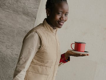 a woman holding a red cup and saucer
