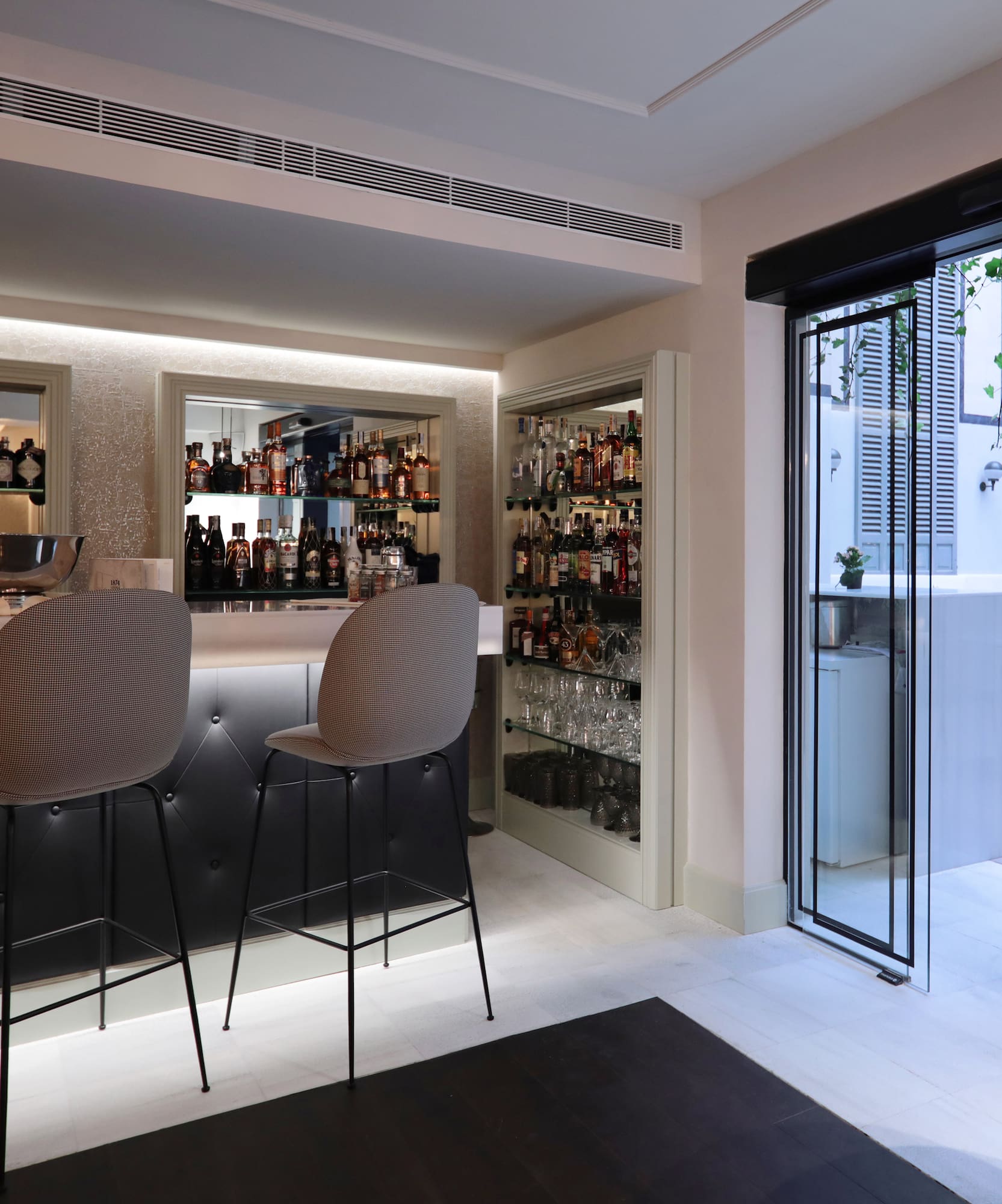 a bar with chairs and shelves of liquor