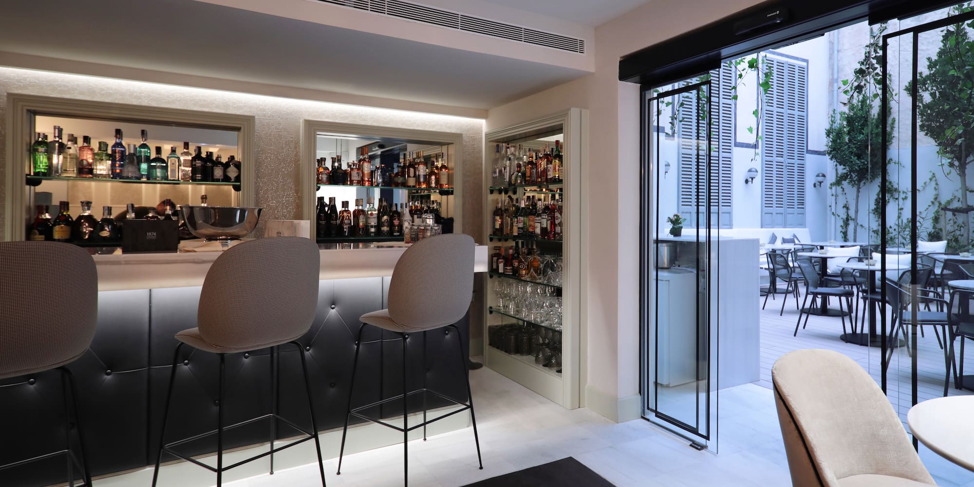 a bar with chairs and shelves of liquor