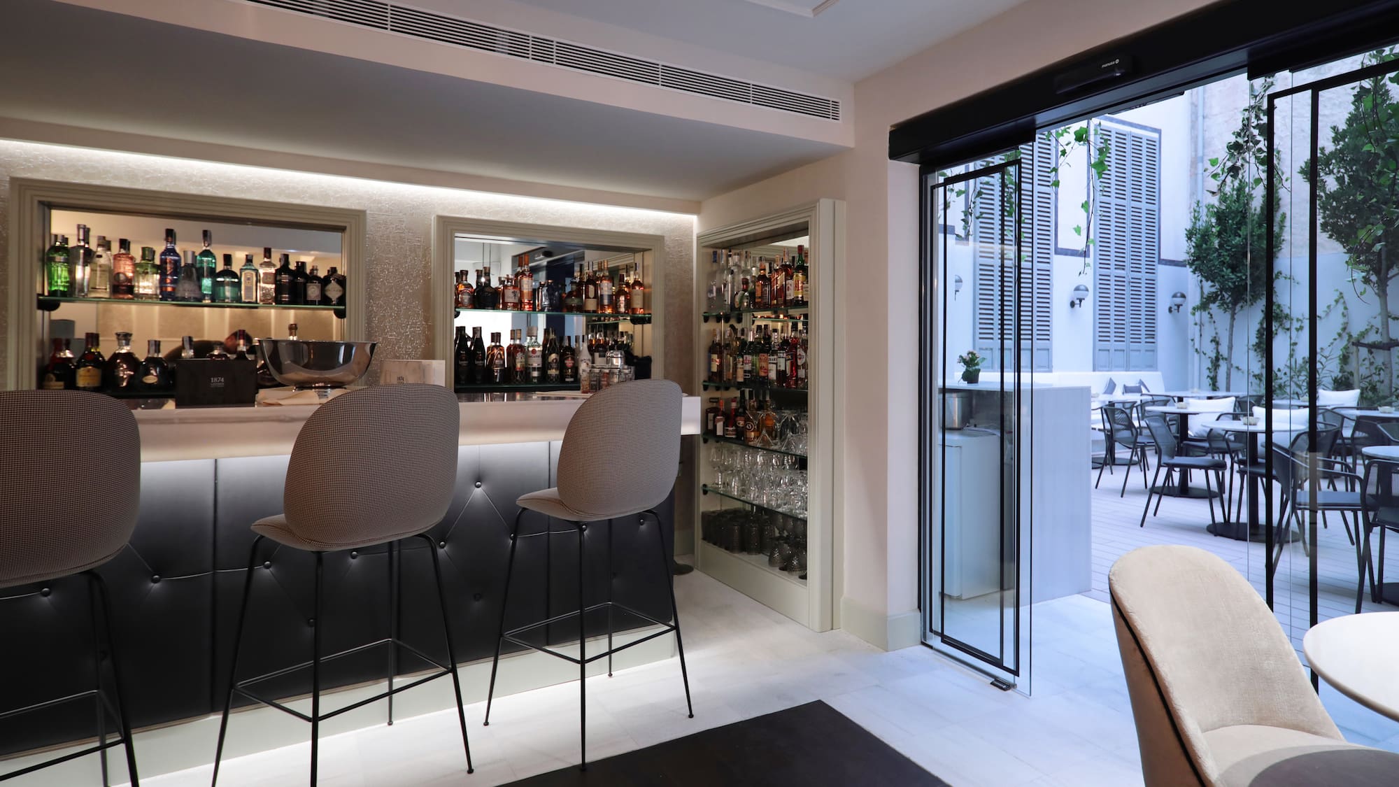 a bar with chairs and shelves of liquor