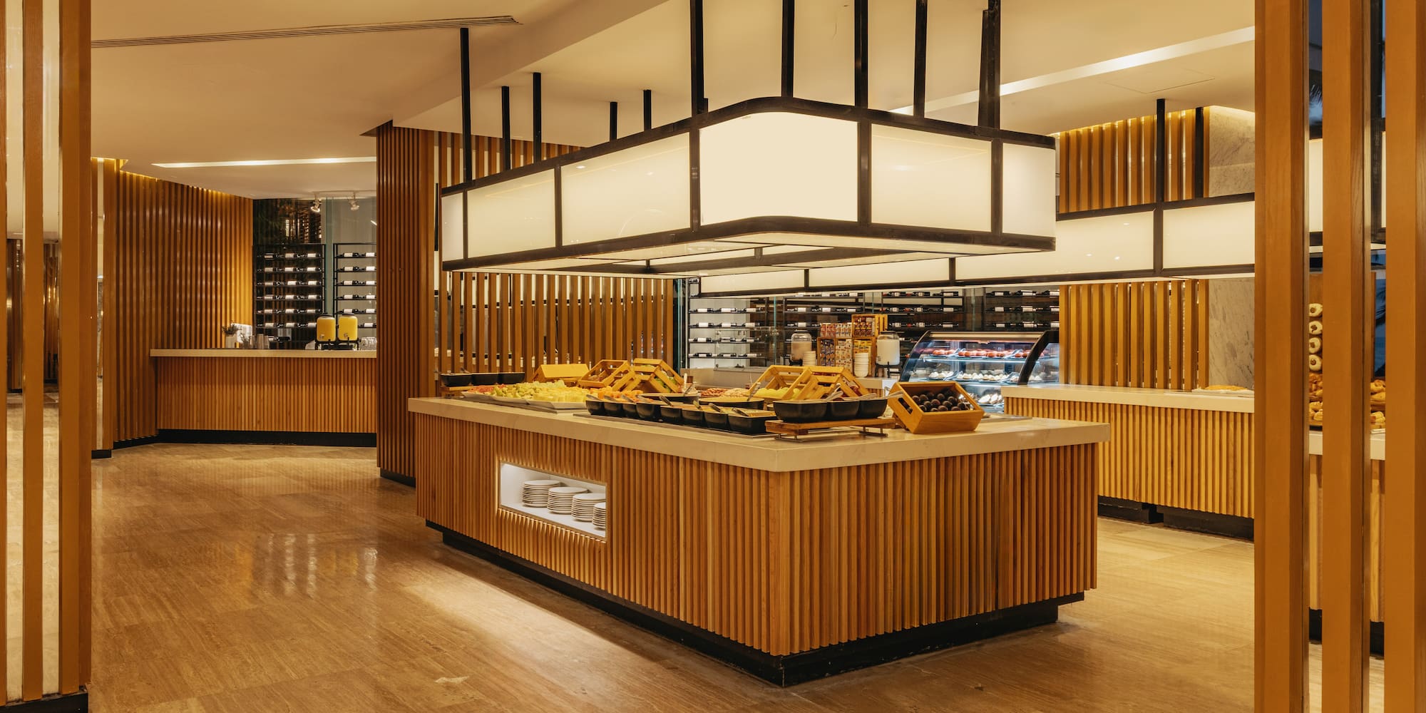 Hotel restaurant buffet with food, wood paneling, and contemporary design.