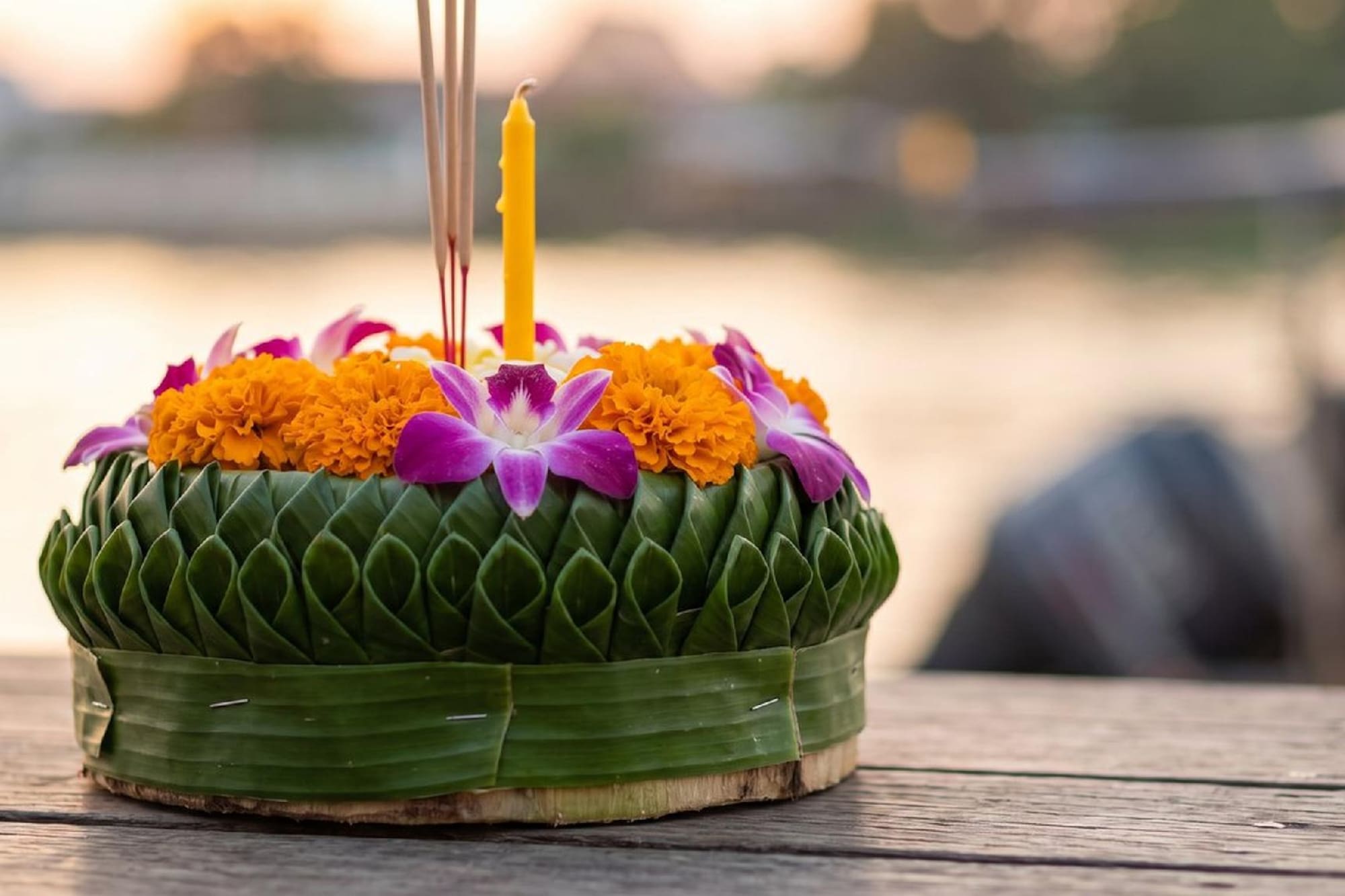 Traditional Loy Krathong banana leaf float with flowers, candle, and incense.