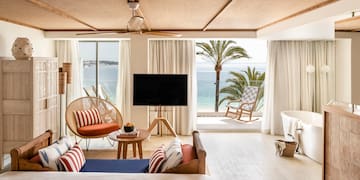 um quarto com uma televisão e uma vista para o oceano