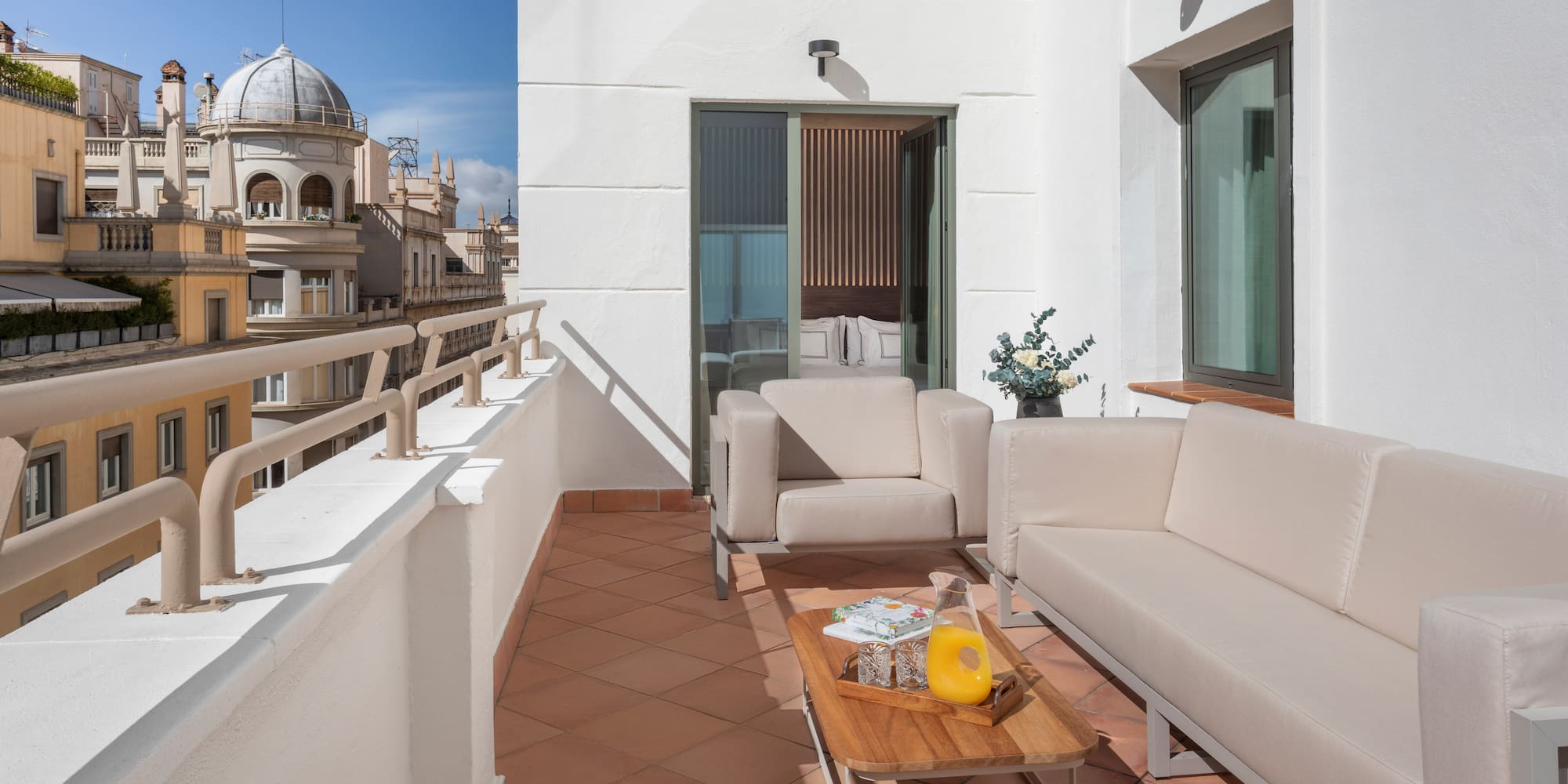 a white couches and a coffee table on a balcony