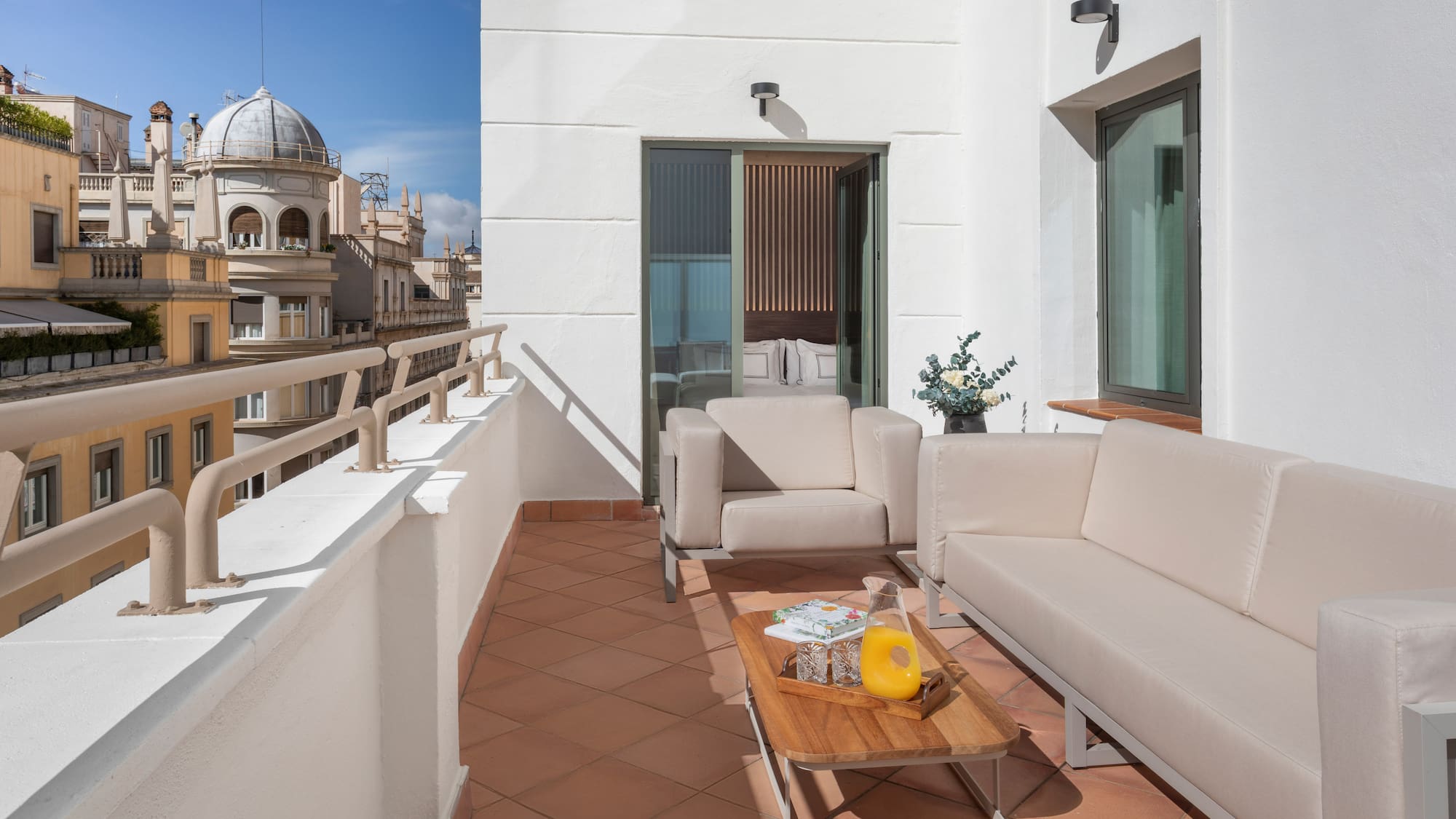 a white couches and a coffee table on a balcony