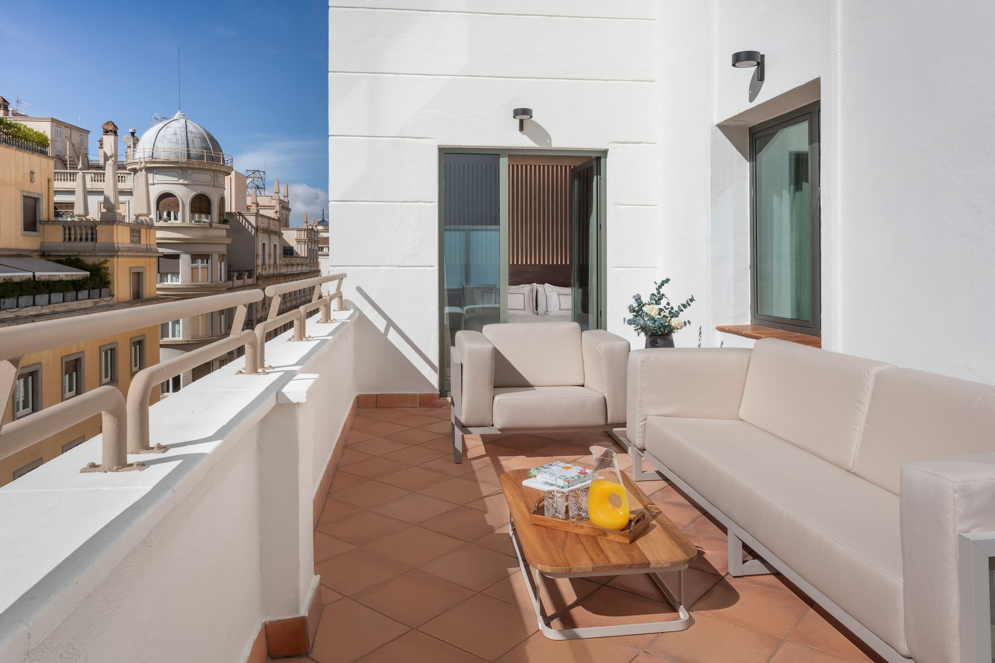 a white couches and a coffee table on a balcony