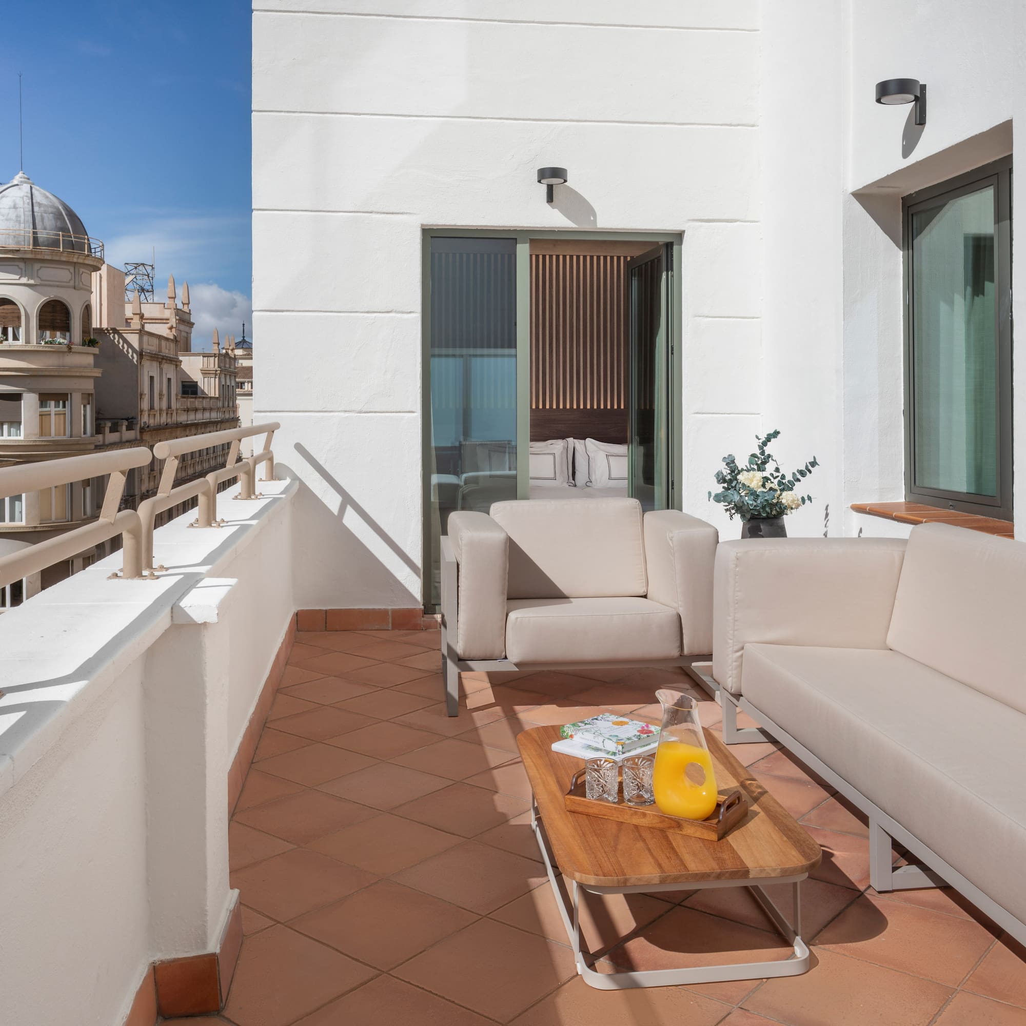 a white couches and a coffee table on a balcony