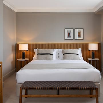 a bed with a bench and lamps in a room