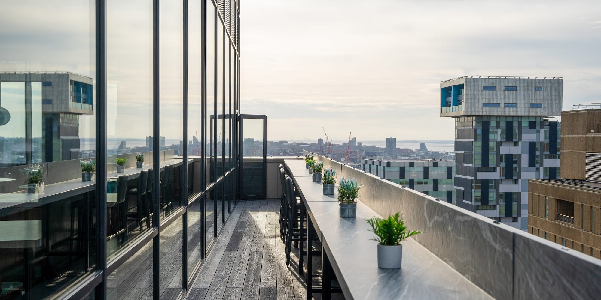 a balcony with a table and chairs and plants on it