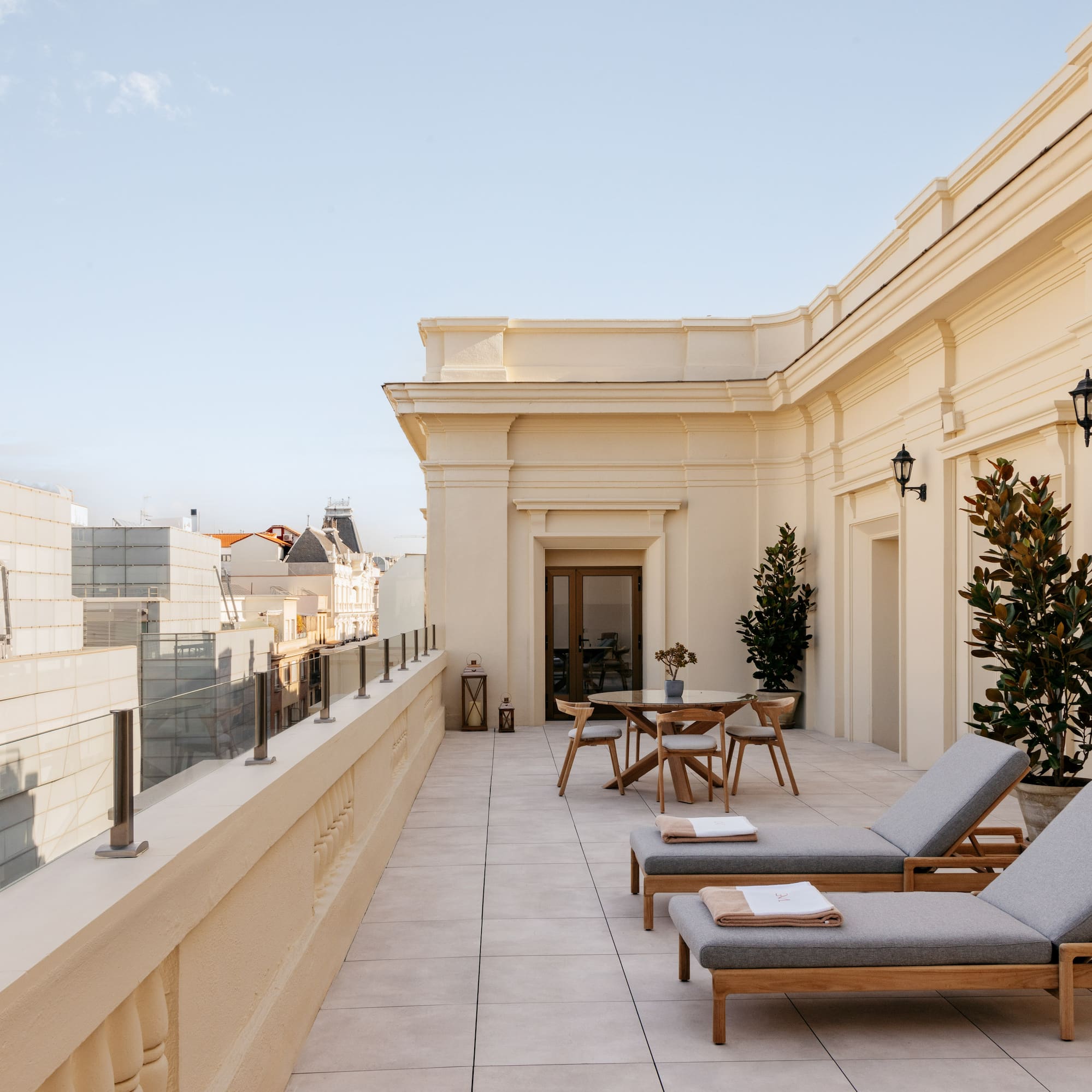 a patio with chairs and tables on a rooftop