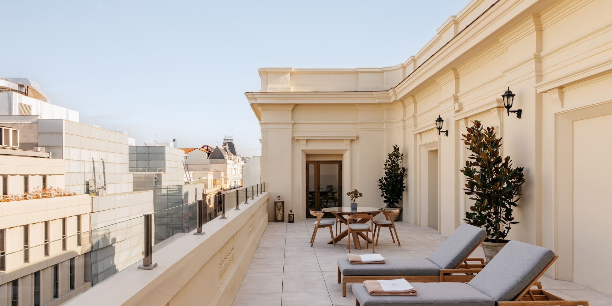 a patio with chairs and tables on a rooftop