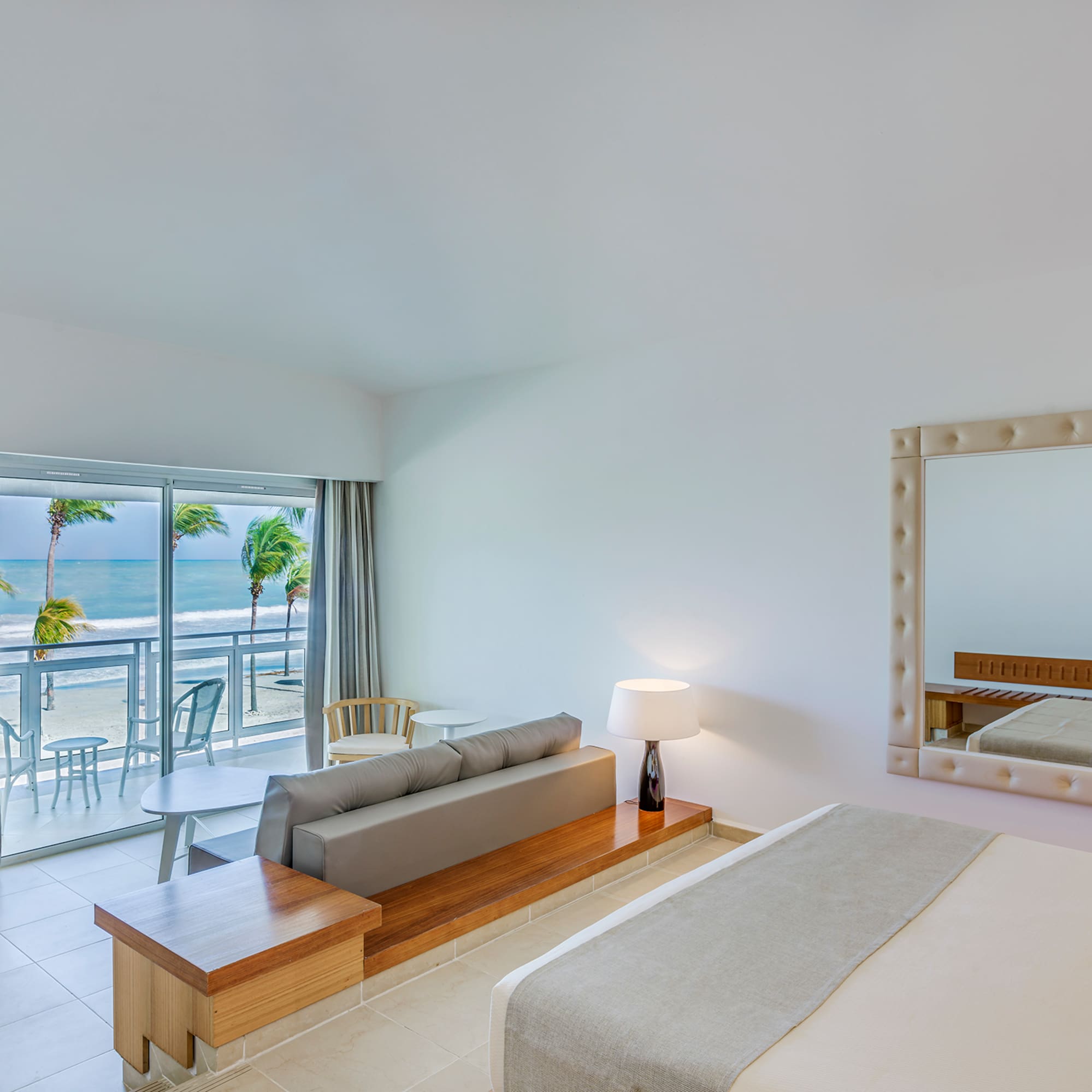 a room with a bed and a mirror and a table