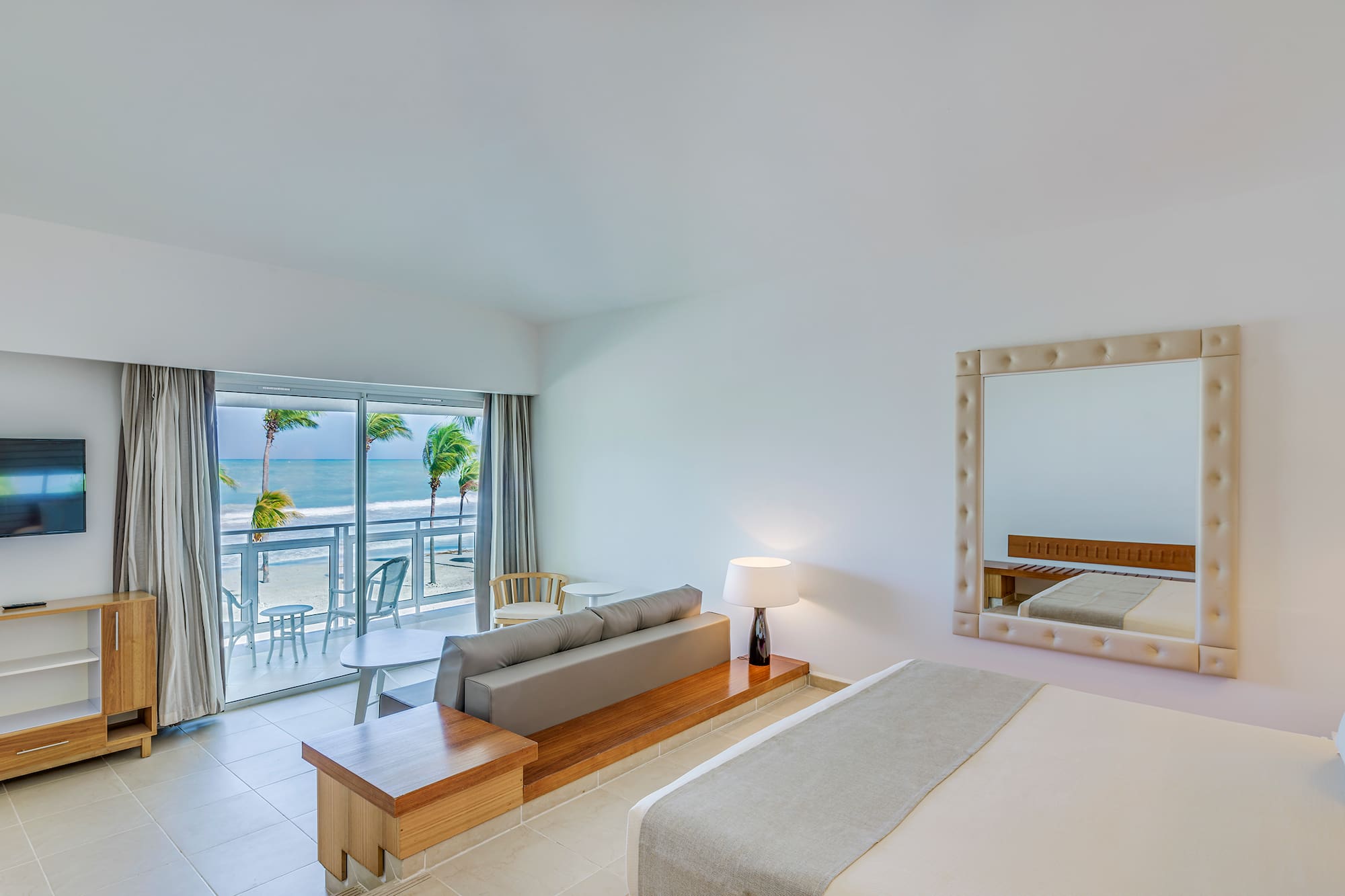 a room with a bed and a mirror and a table